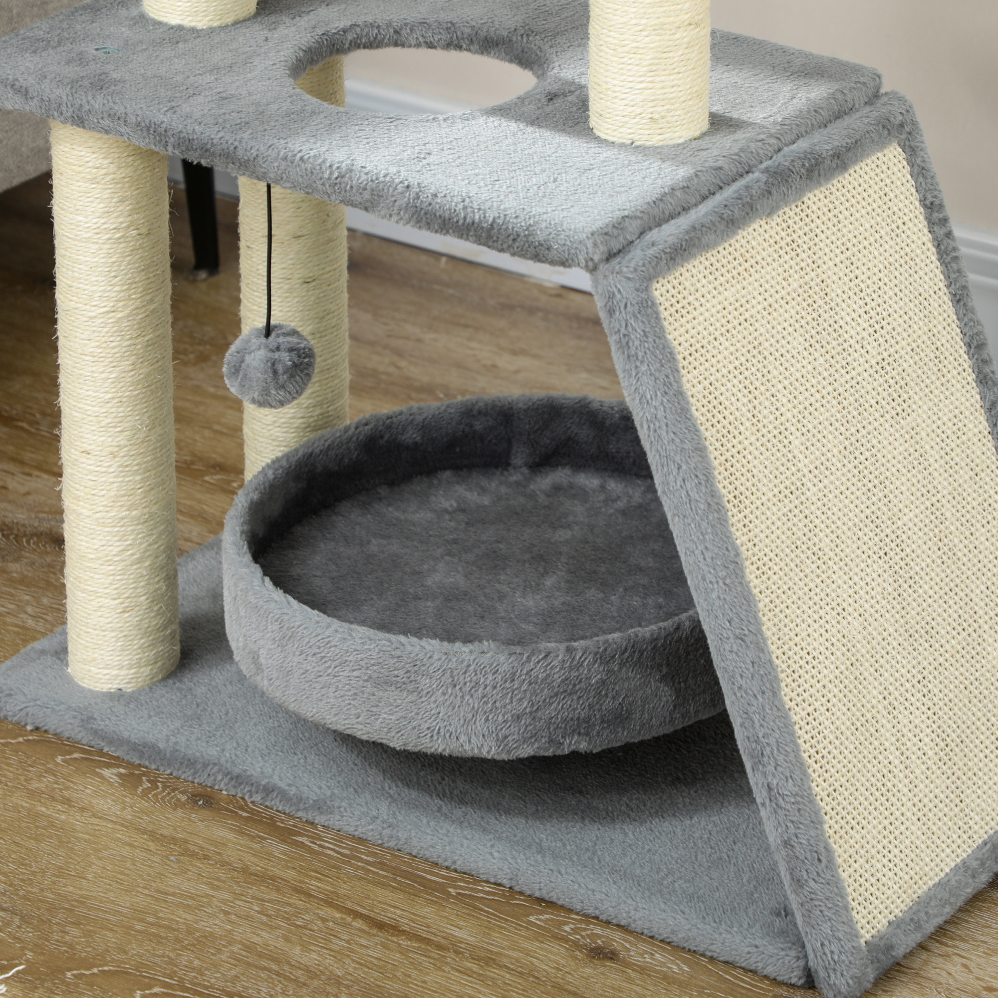 Un árbol para gatos gris con cama, rascador, rampa y bola colgante.