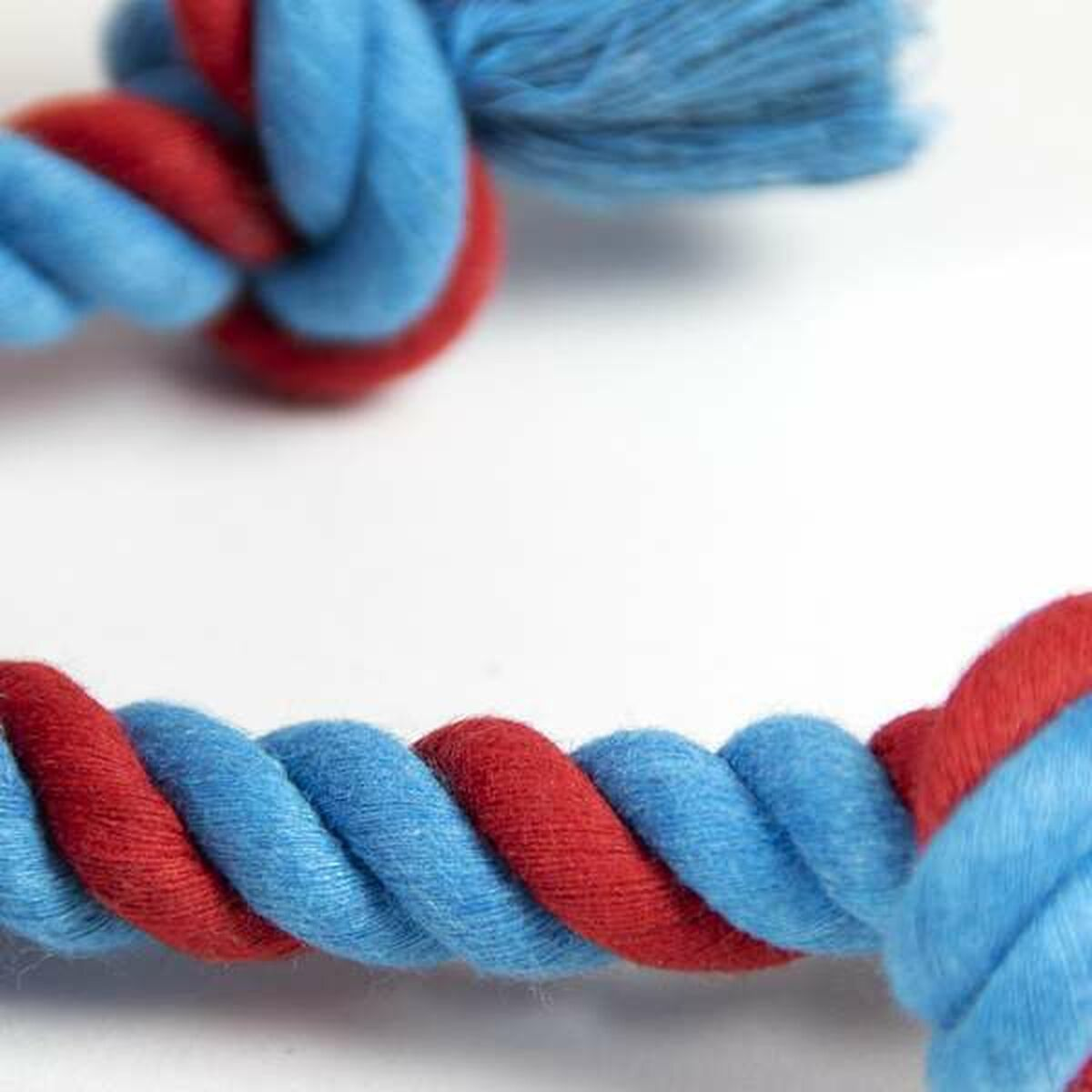 Un primo piano di una corda intrecciata, rossa e blu, con nodi.