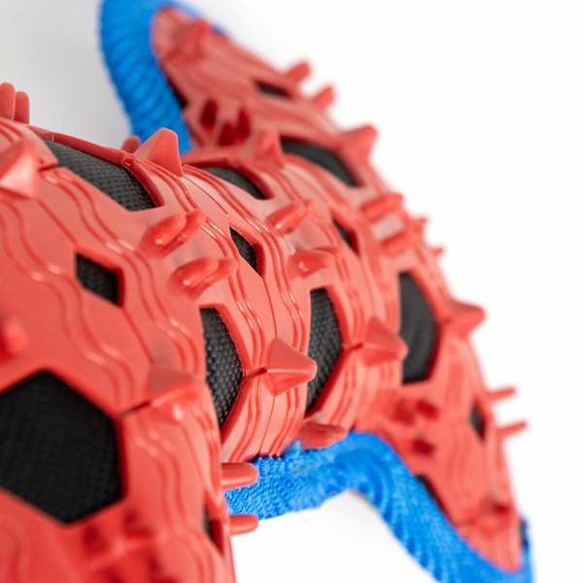 Nahaufnahme eines roten und blauen Hundespielzeugs. Rote Stacheln an den Rändern. Blaue und schwarze Details.
