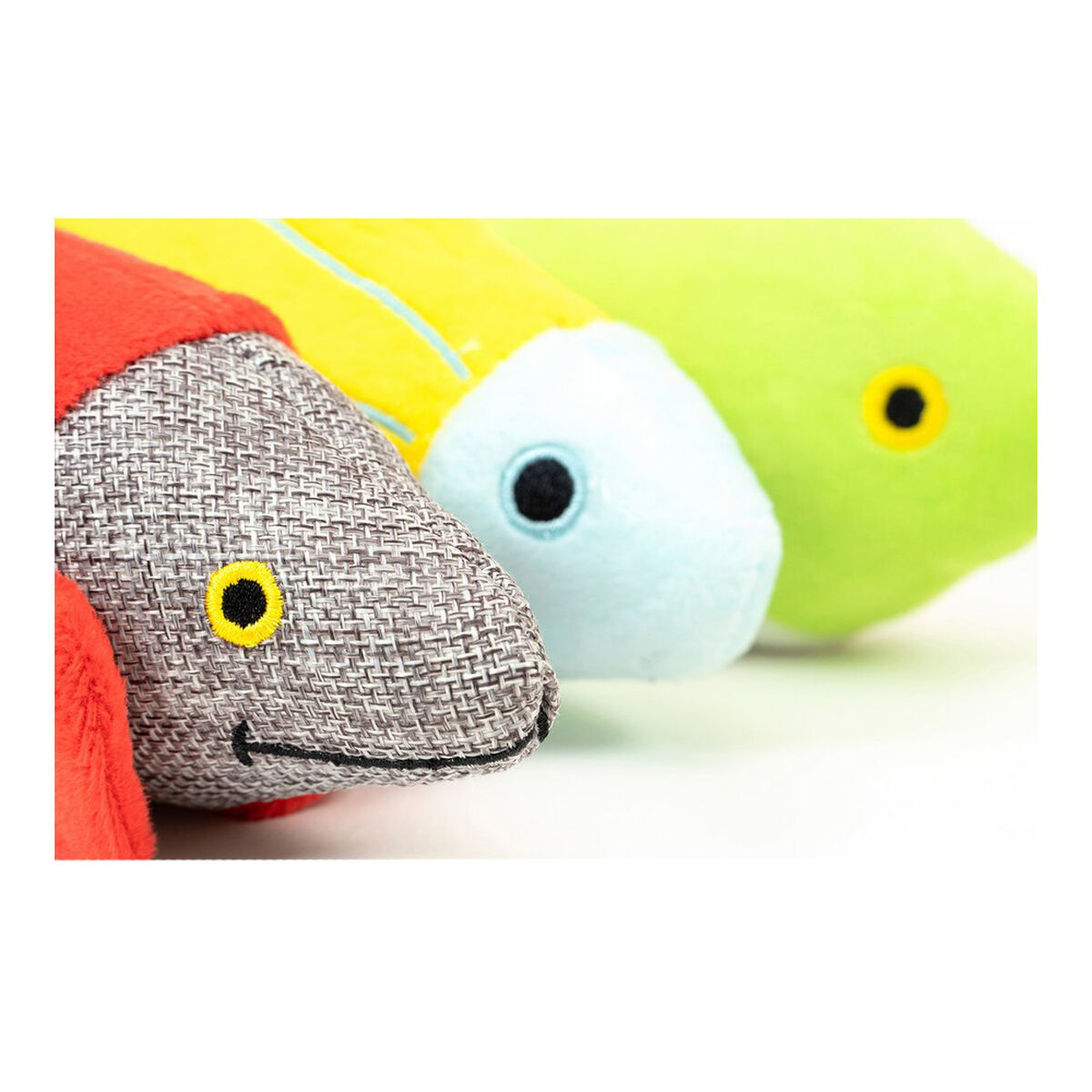 Nahaufnahme von drei bunten Fischspielzeugen mit gelben Augen.