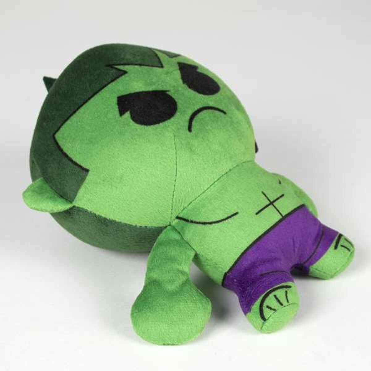 Peluche di Hulk verde con pantaloncini viola, sdraiato.