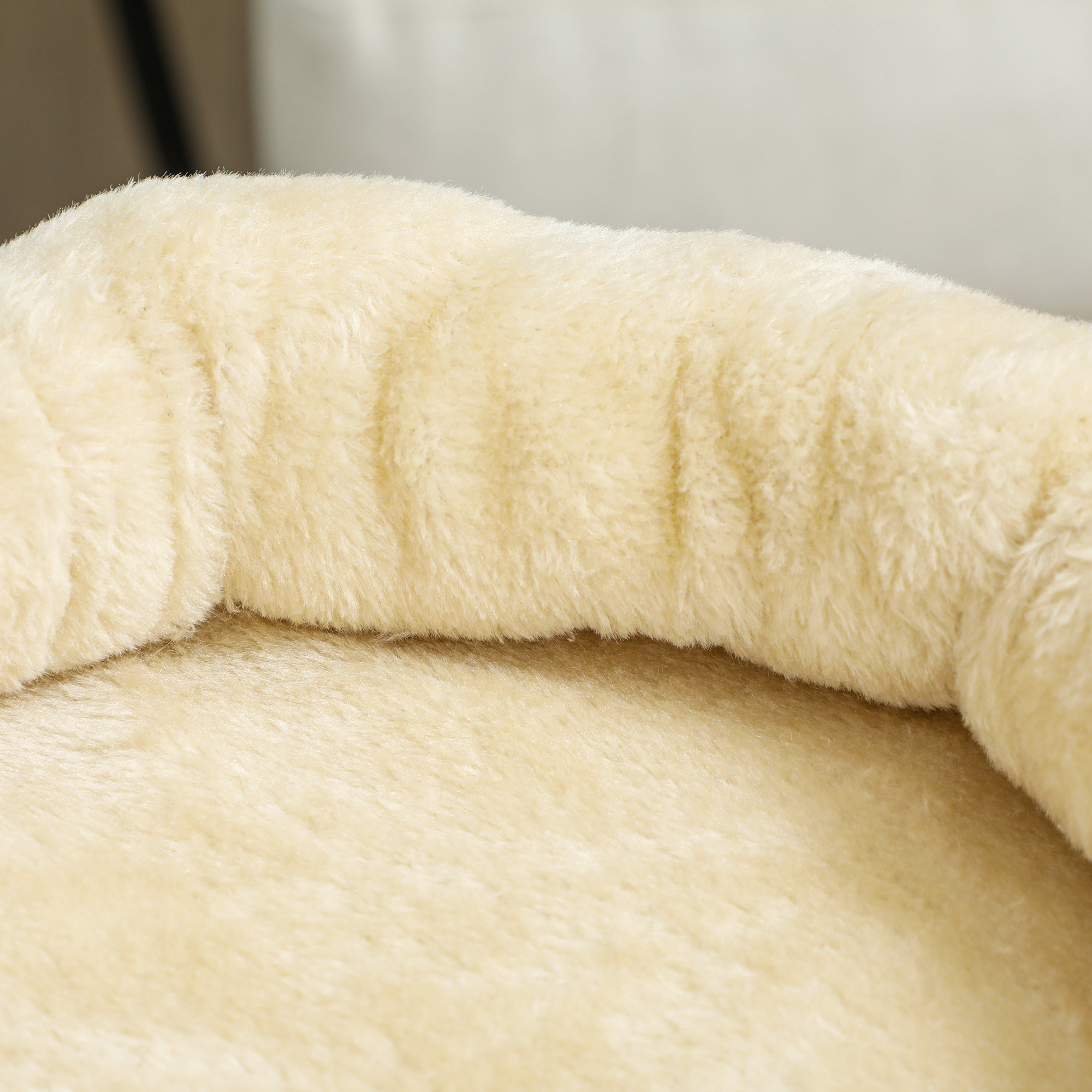 Primer plano de una cama de árbol para gatos beige claro y esponjosa.