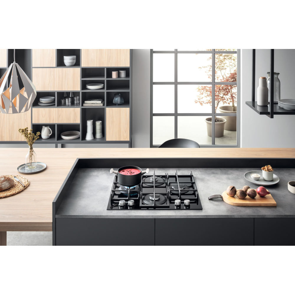 Una cucina con piano cottura a gas con una pentola di cibo su un fornello. Design moderno.