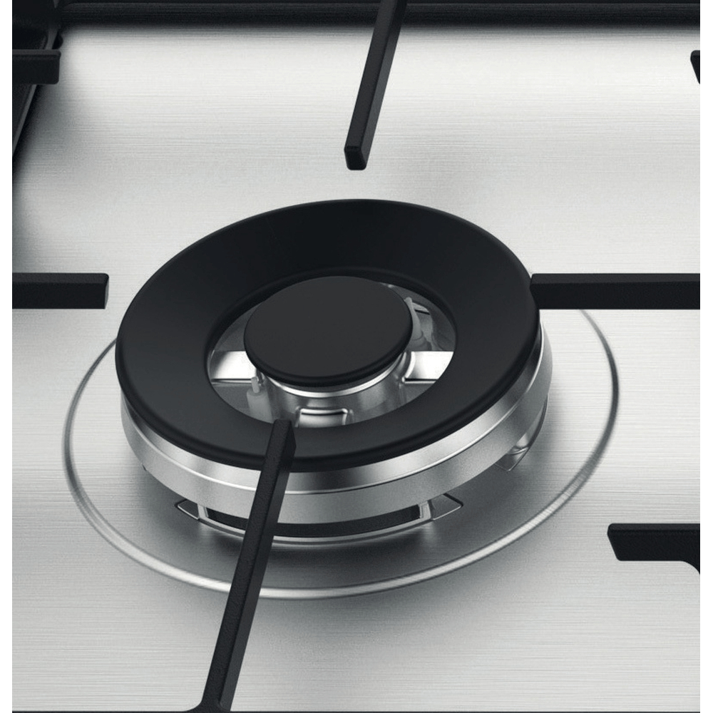 Primer plano de un quemador de encimera de gas. Quemador negro con anillo plateado sobre acero inoxidable.
