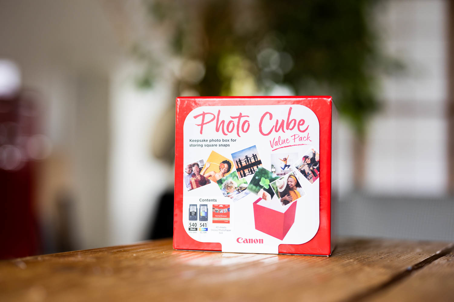 A Canon color laser cartridge box is white. The cartridge is black and orange.