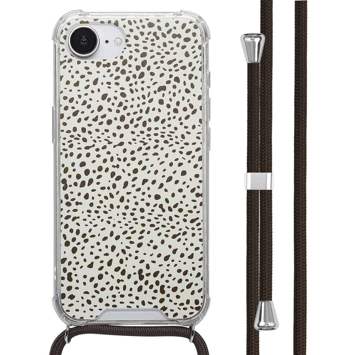 Téléphone avec étui à pois et cordon brun, suspendu. Étui transparent visible.