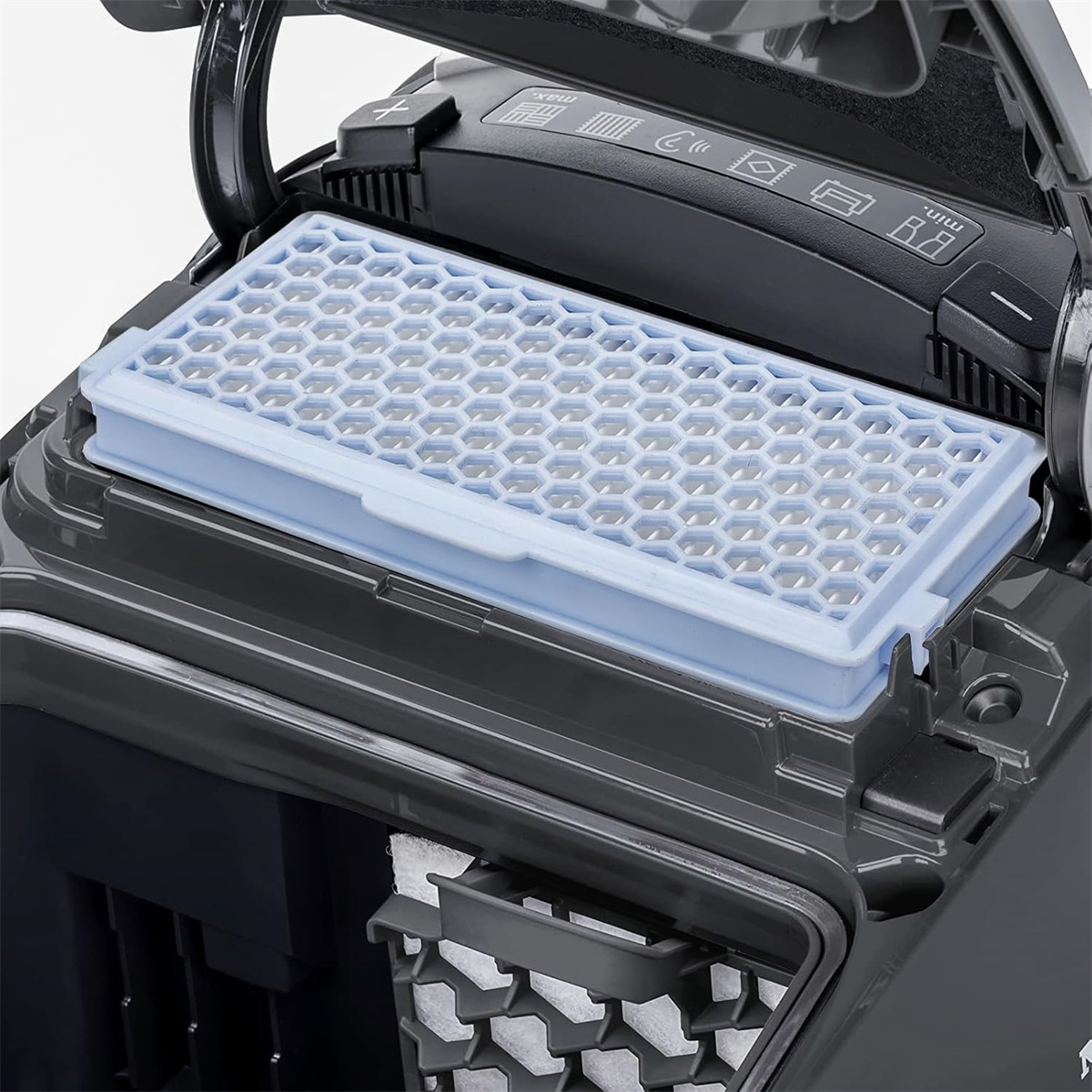 Nahaufnahme des Innenfilters eines Staubsaugers. Der Filter hat eine hellblaue Wabenform.