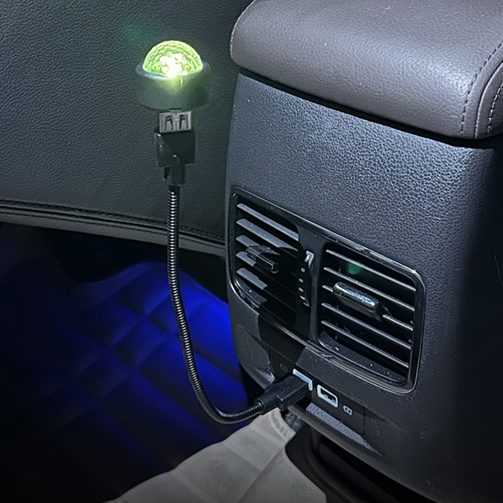Auto-Innenraum mit USB-betriebener LED-Leuchte. Das Licht ist im Rücksitz, in der Nähe der Lüftungsschlitze. Dunkelblaues Umgebungslicht.