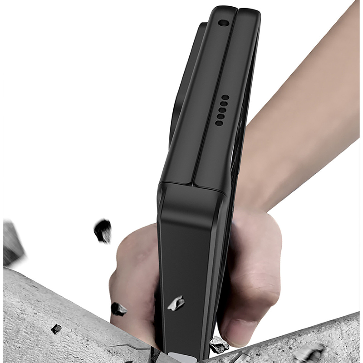 Eine schwarze Handyhülle wird gegen eine graue Oberfläche gedrückt, mit Trümmern, die einen Aufprall oder Sturztest vermuten lassen.