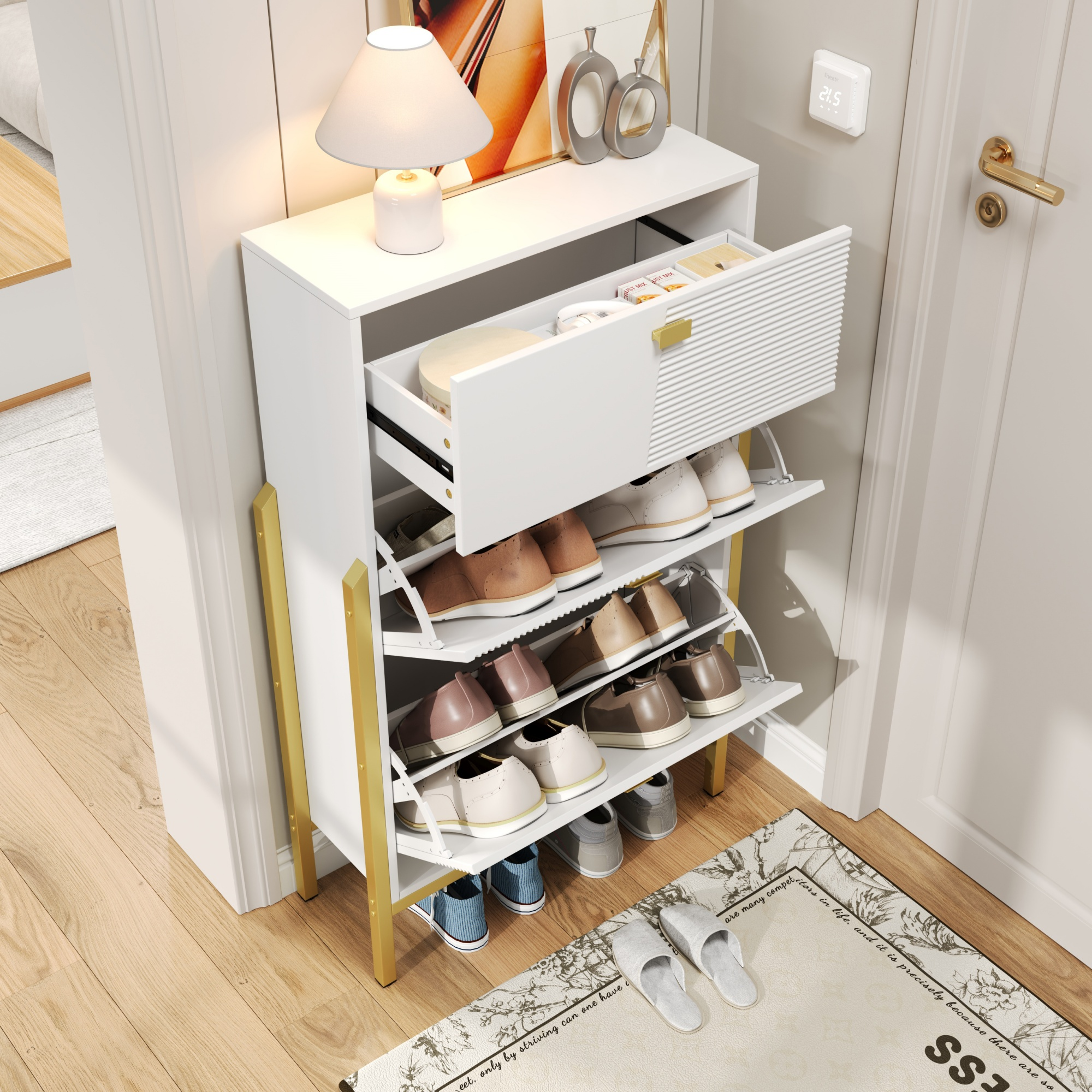 Ein weißer Schuhschrank mit offenen Schubladen voller Schuhe. Goldene Beine. Lampe und Dekoration oben.
