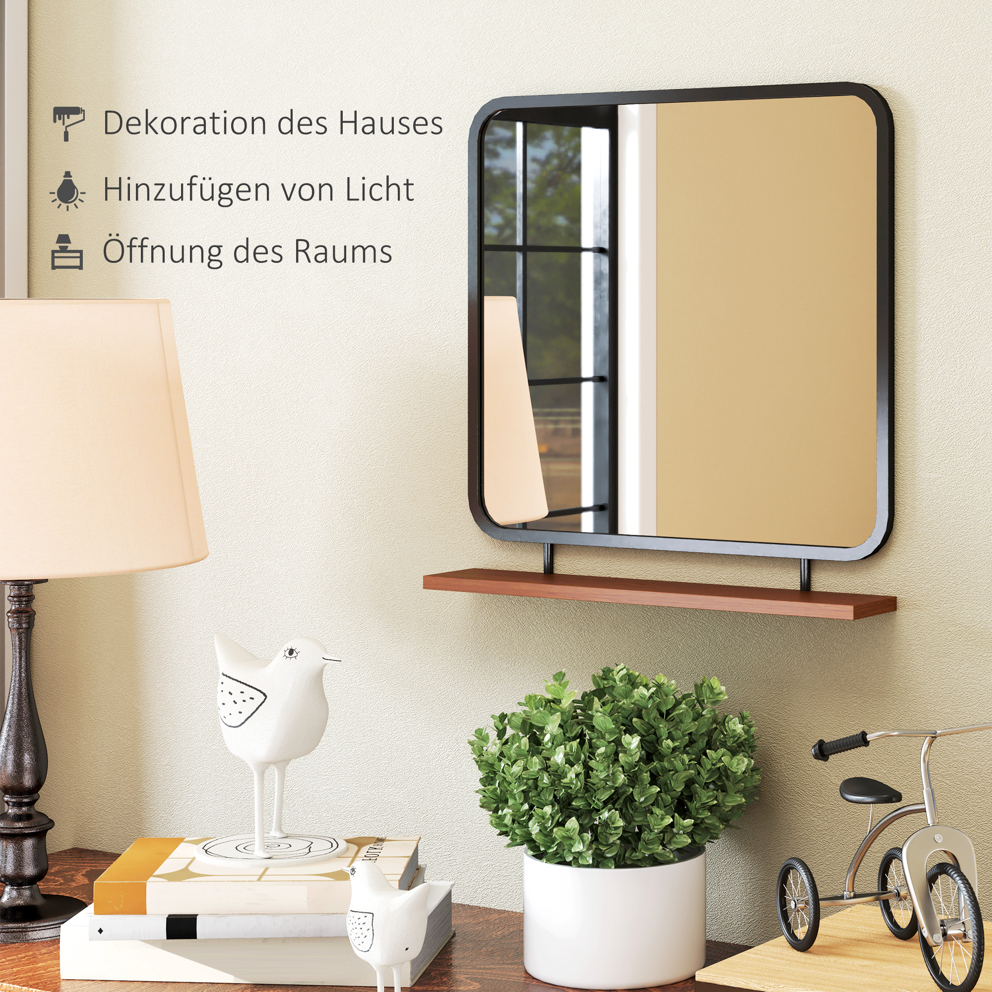 Ein Spiegel an einer Wand mit dekorativen Gegenständen. Eine Lampe, Bücher und eine Pflanze stehen auf einem Tisch unter dem Spiegel.