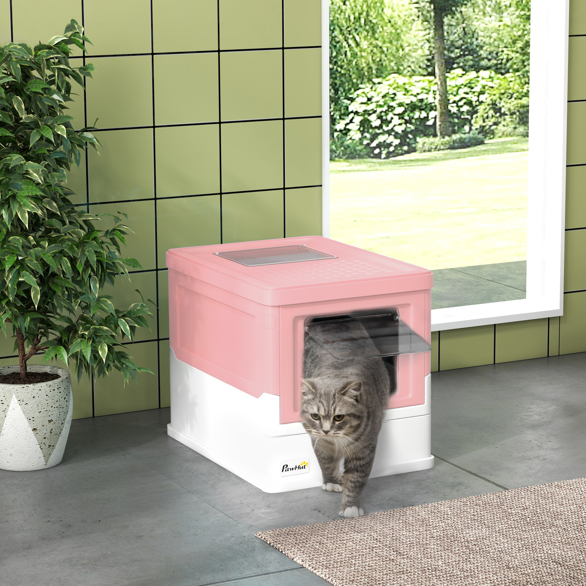 Un gato sale de una caja de arena rosa y blanca. La habitación tiene una pared de azulejos verdes y una ventana.