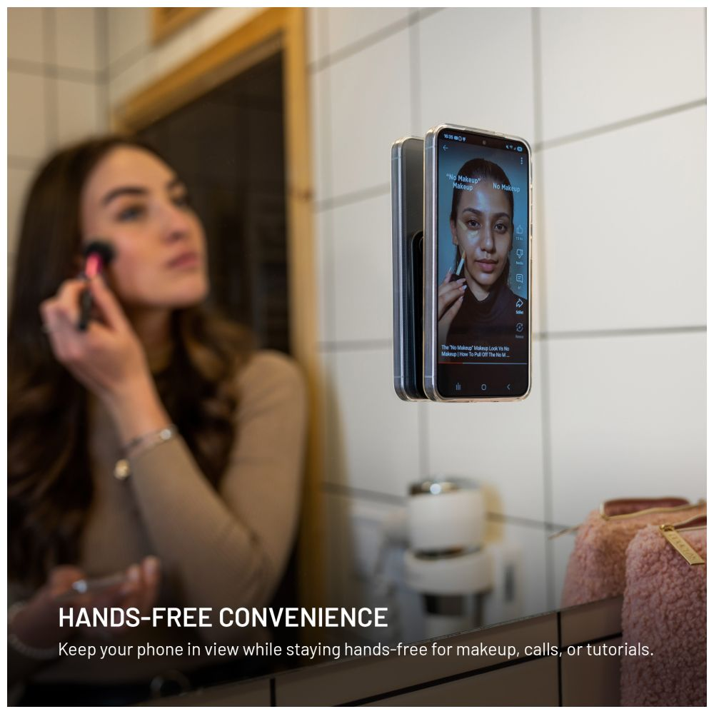 Frau schminkt sich, blickt auf Telefon am Spiegel. Text: Hands-Free Convenience.