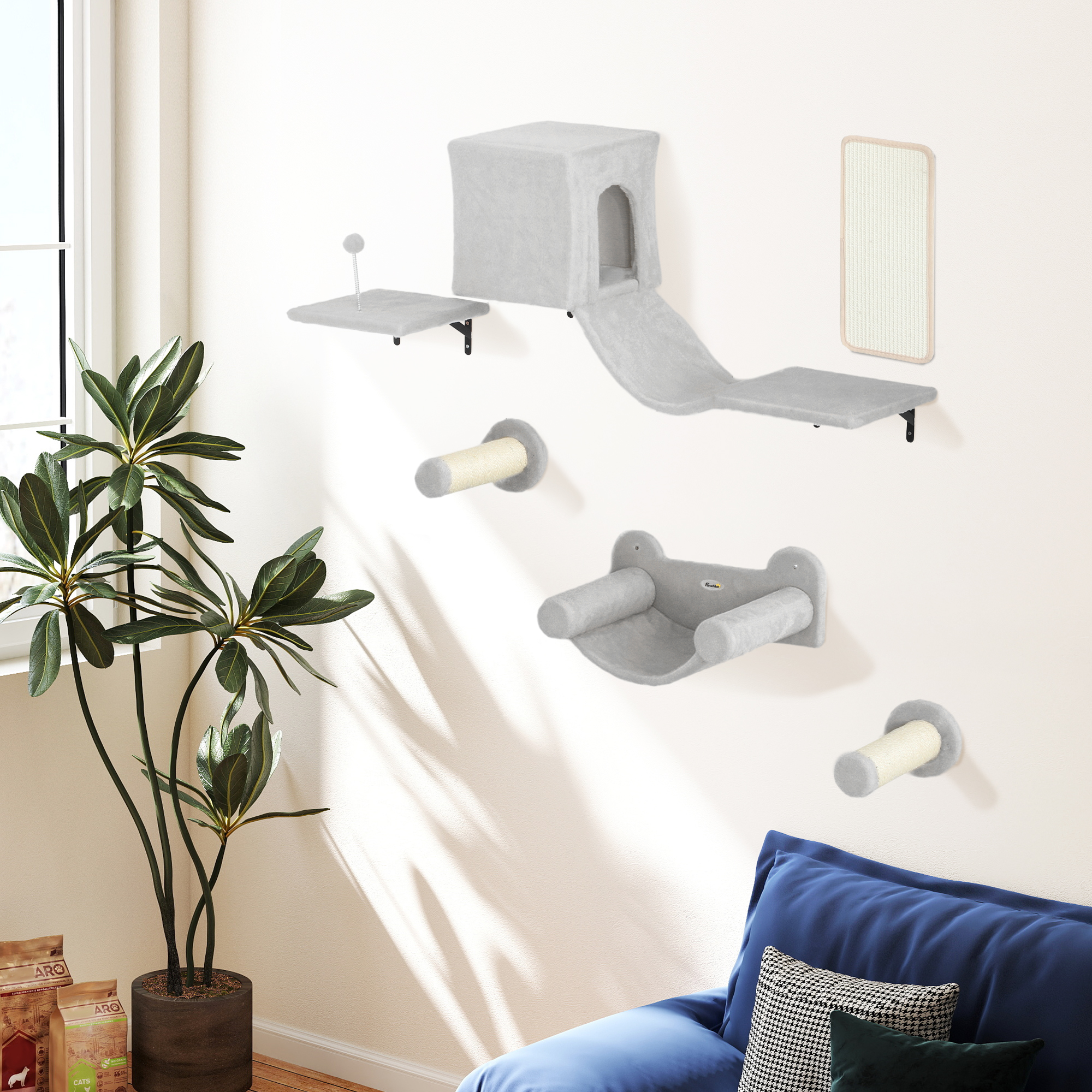 Juego de muebles para gatos en una pared. Incluye estantes, una casa y postes rascadores. Una planta y un sofá a la vista.