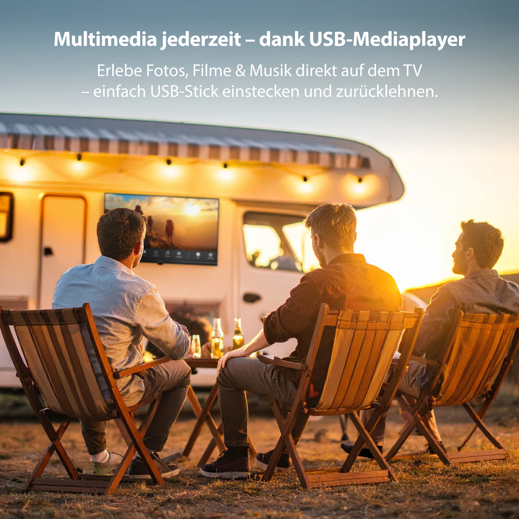 Drei Männer sitzen bei Sonnenuntergang in Stühlen vor einem Wohnmobil und schauen einen Fernseher an der Außenseite des Wohnmobils.