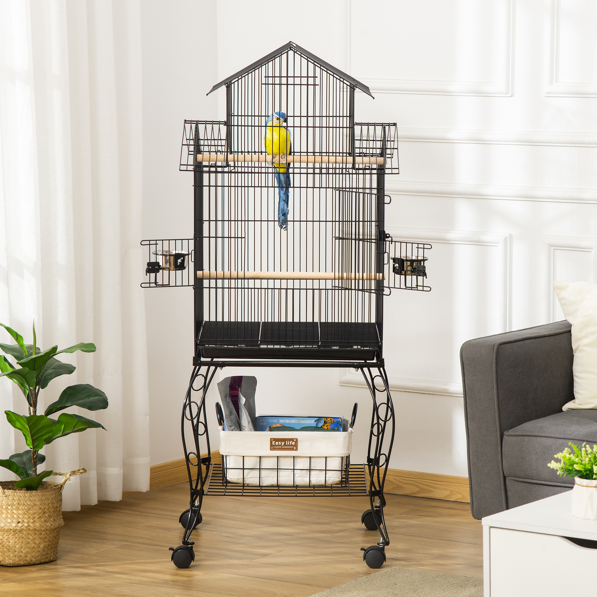 Una jaula negra con un pájaro azul y amarillo dentro, colocada en una habitación luminosa.