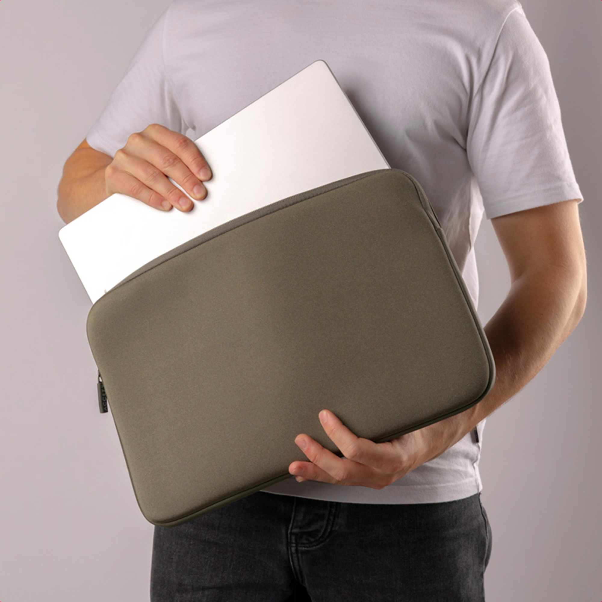 A man holding a laptop inside an olive-green case.