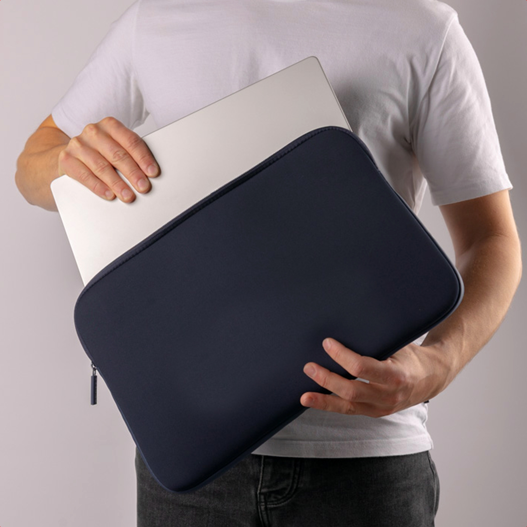 A man holding a laptop inside a dark blue case.