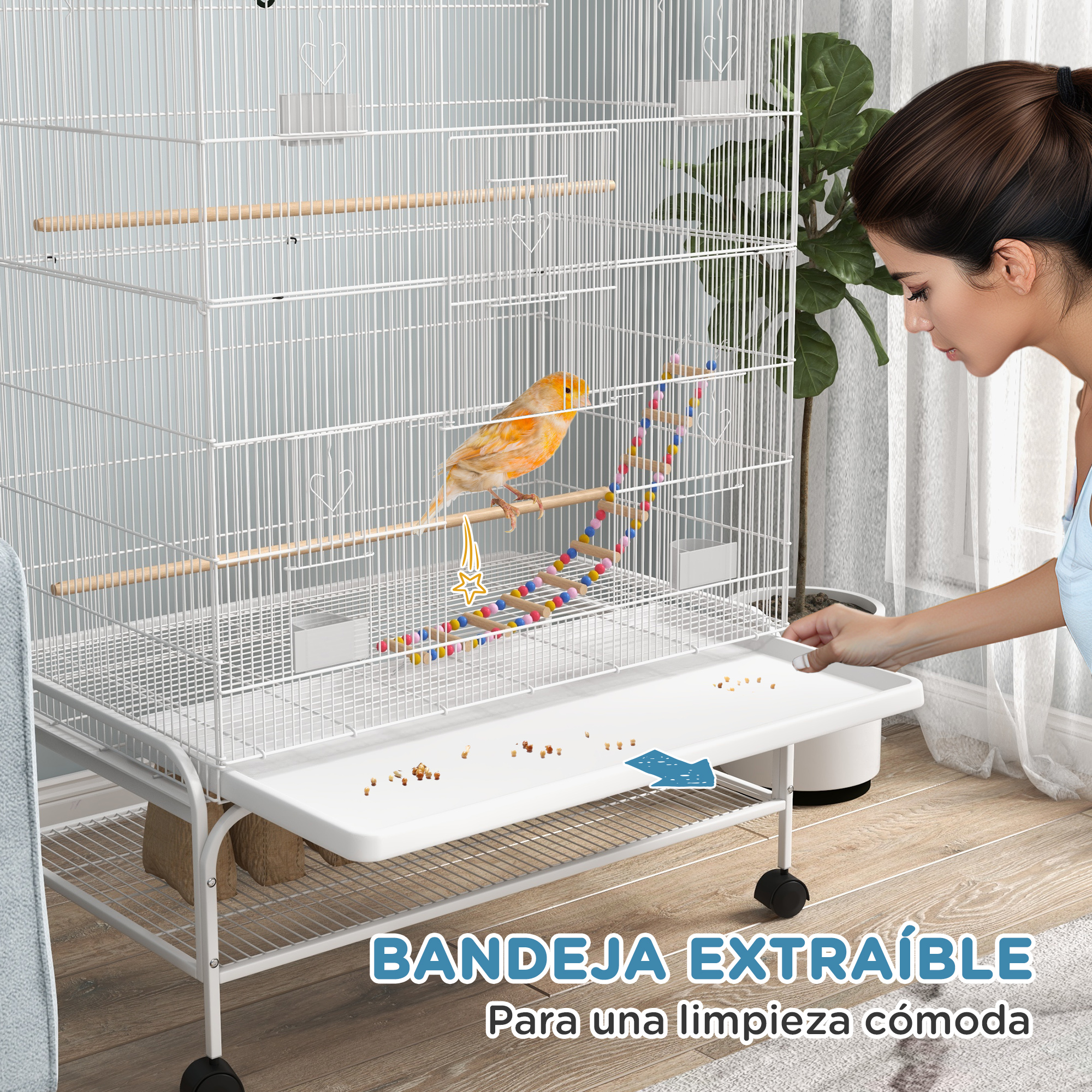 Una mujer limpiando una jaula para pájaros. Tiene una bandeja extraíble para facilitar la limpieza.