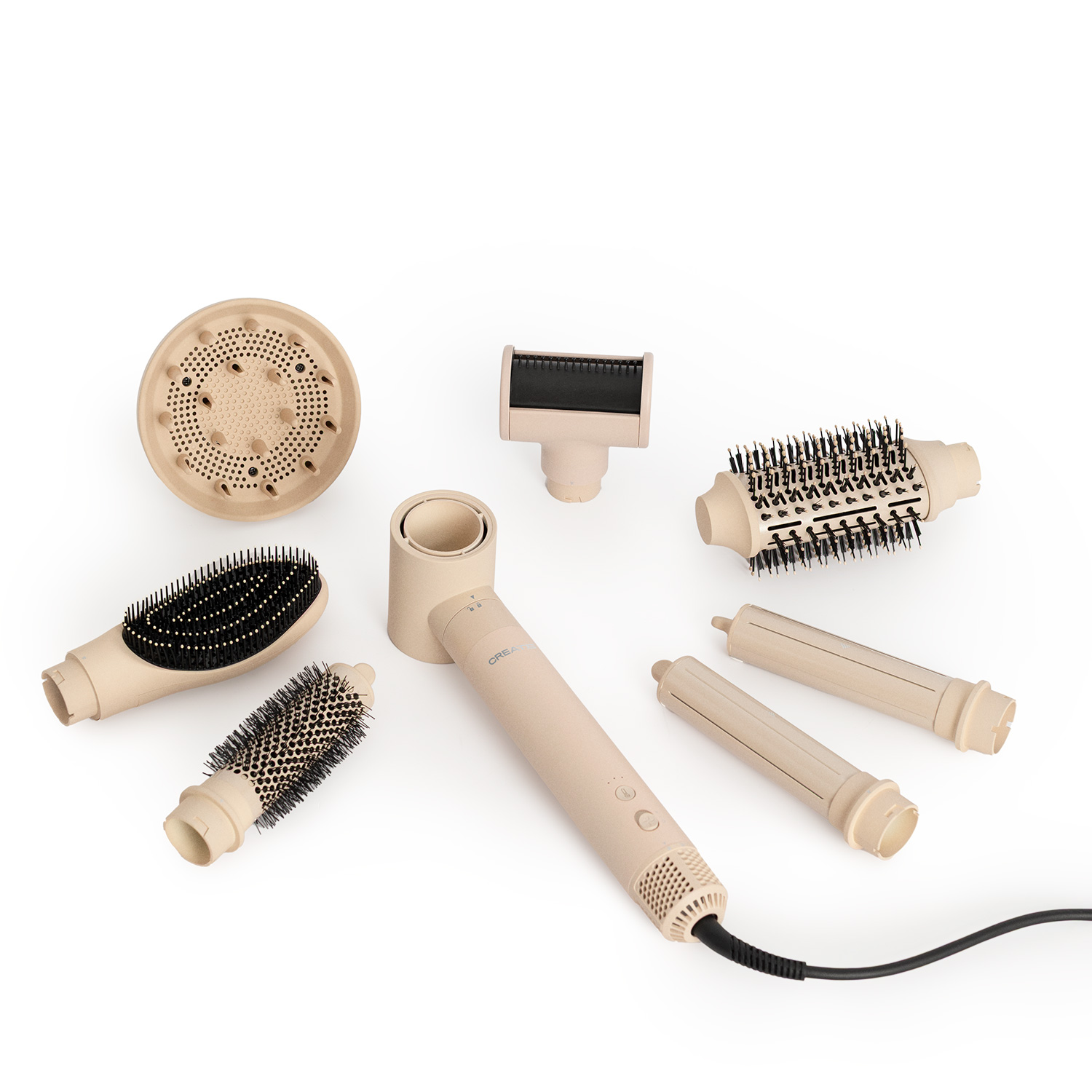 Una variedad de accesorios de peinado beige y un secador de pelo están dispuestos sobre una superficie blanca.