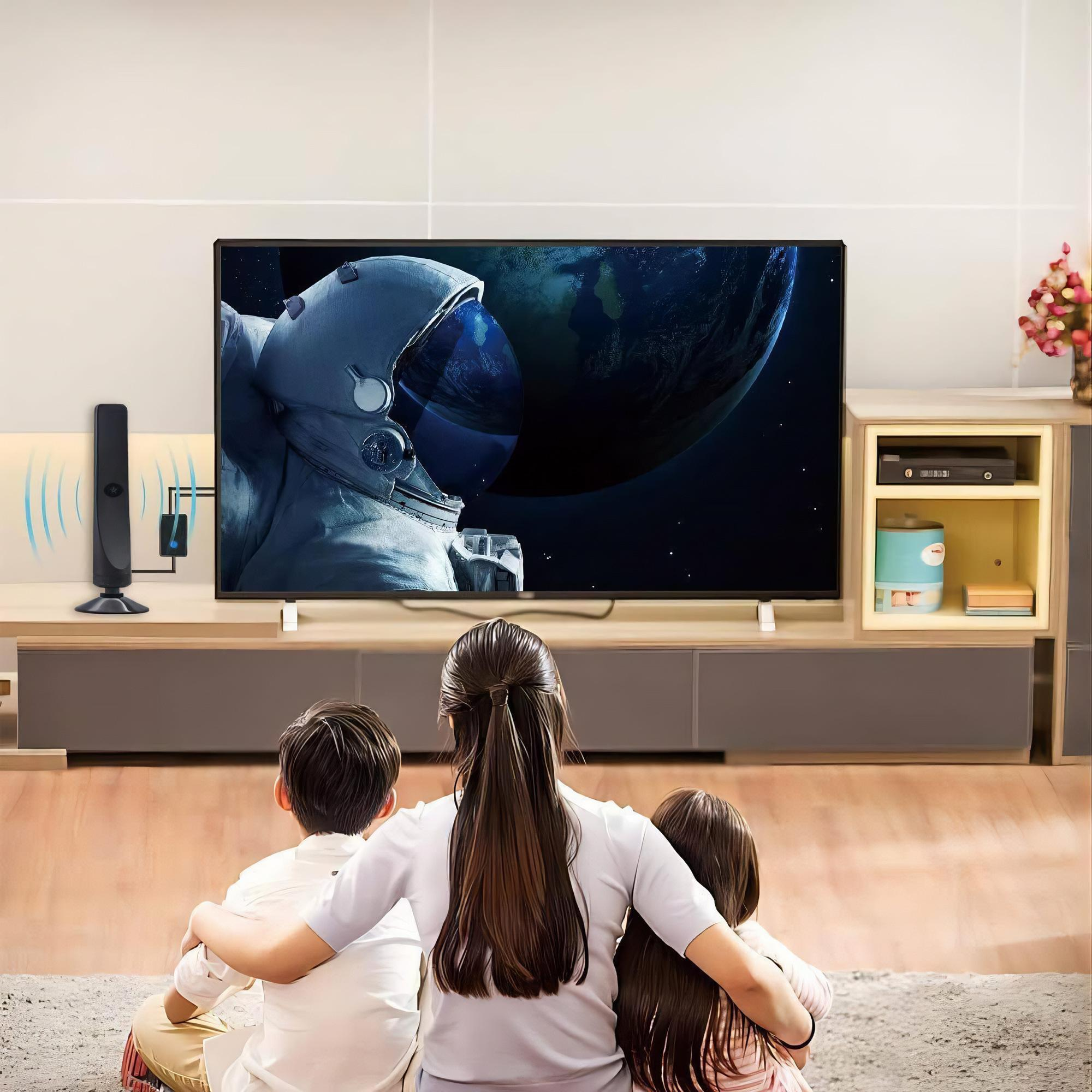 Familie schaut mit einer Antenne fern, wobei ein Astronautenbild auf dem Bildschirm in einem Wohnzimmer gezeigt wird.