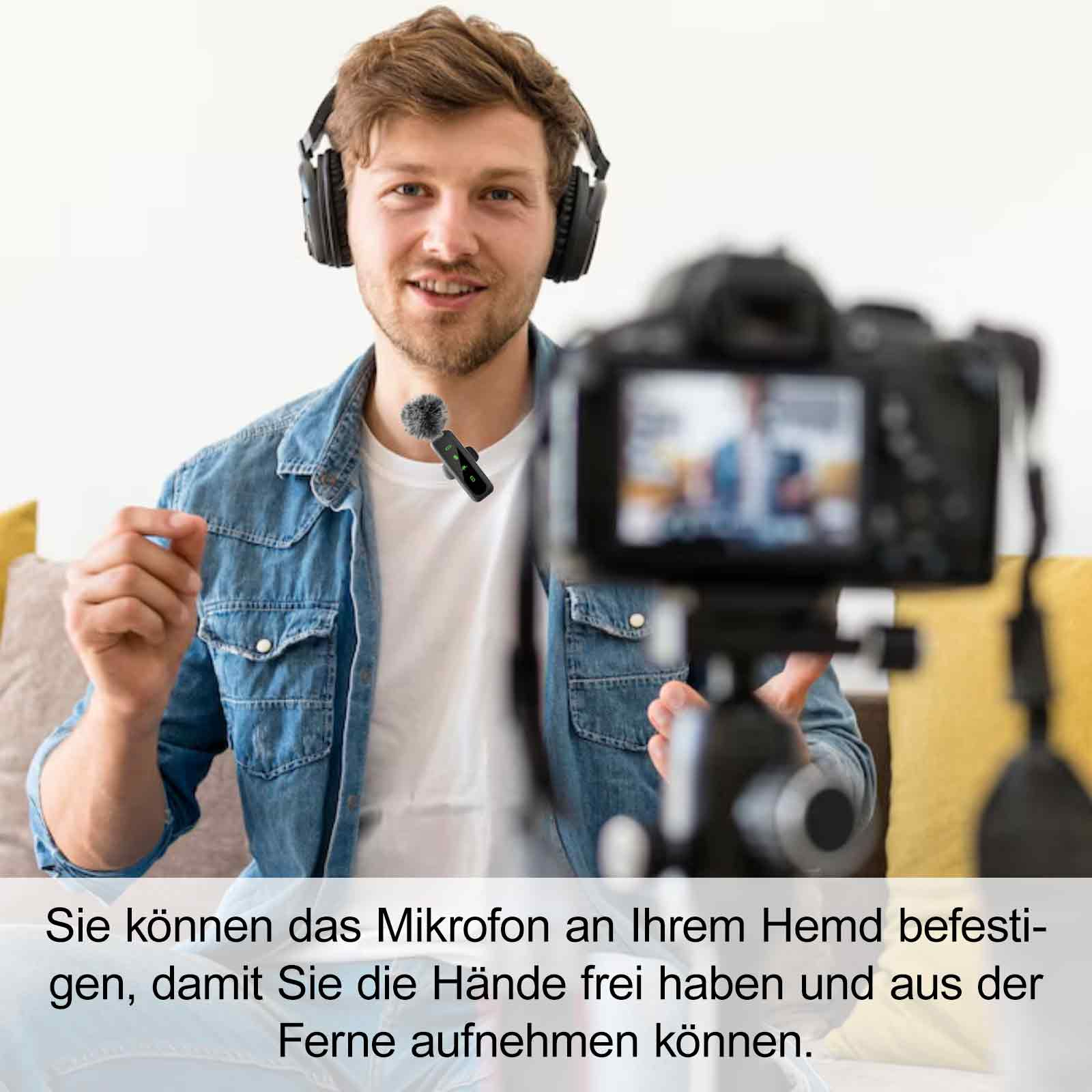 Ein Mann mit Kopfhörern und einem an seinem Hemd befestigten Mikrofon. Er lächelt vor einer Kamera.