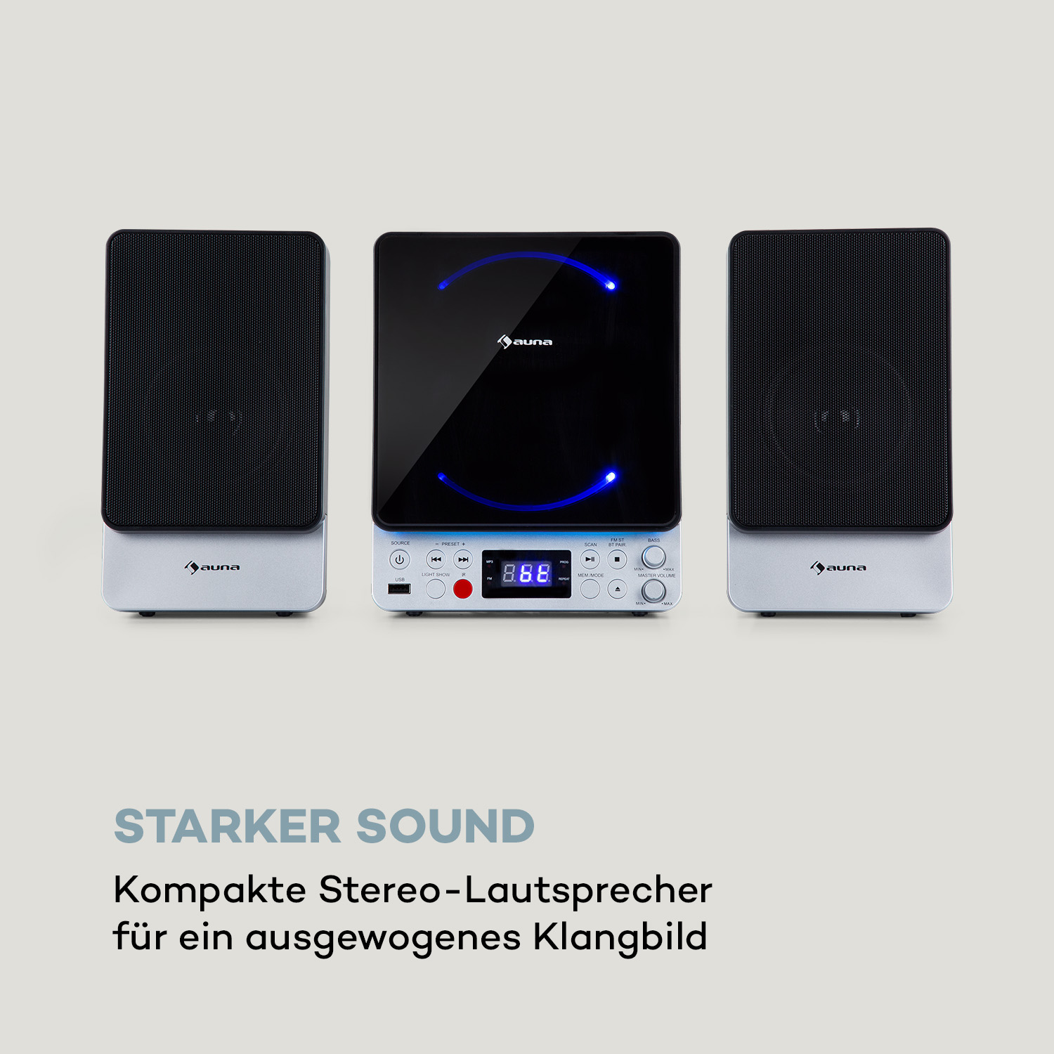 Drei Lautsprecher mit silbernen Sockeln. Mittiger Lautsprecher hat Display und die Worte Starker Sound.