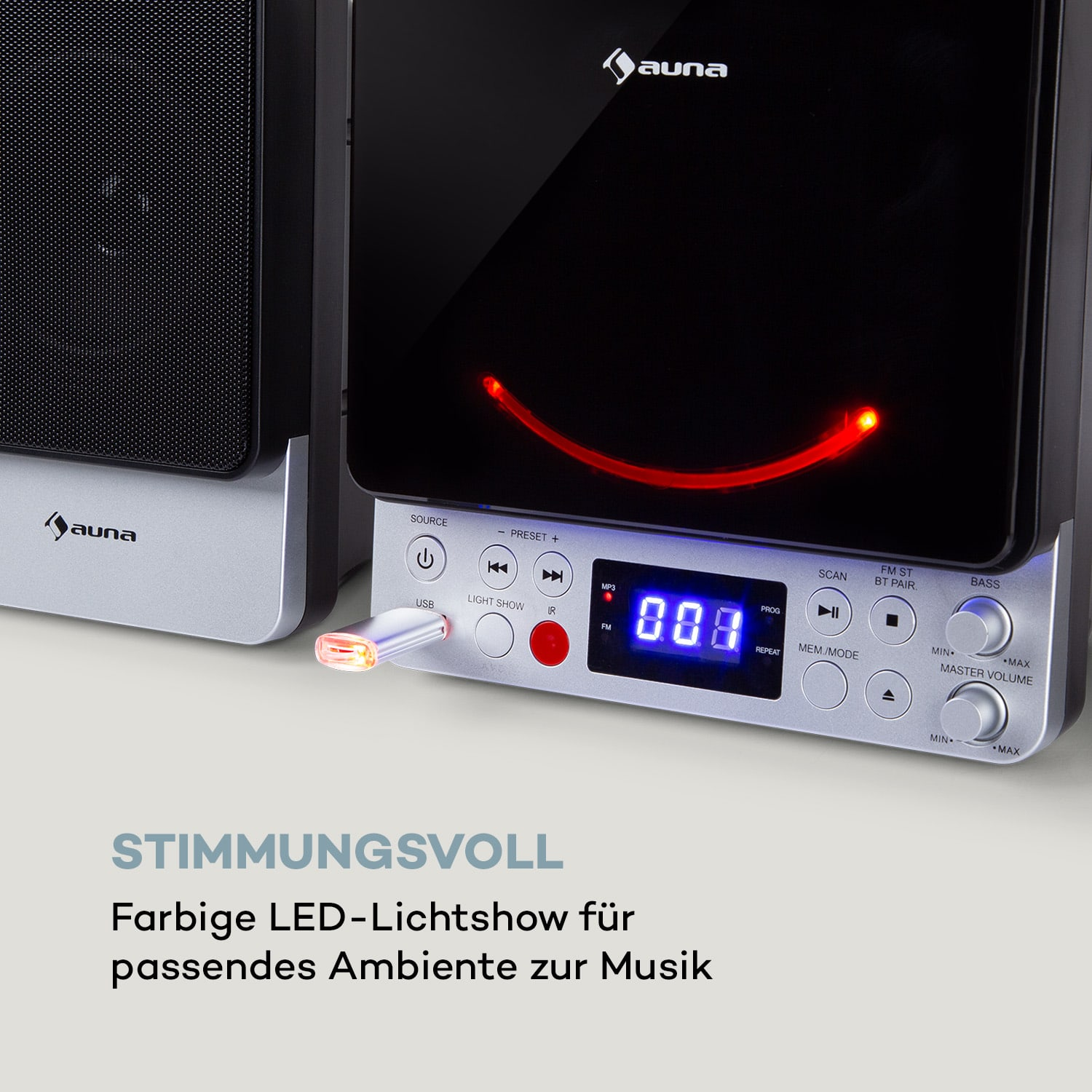 Ein schwarzes Audiosystem mit eingestecktem USB-Laufwerk. Ein rotes Licht leuchtet mit blauem Display.