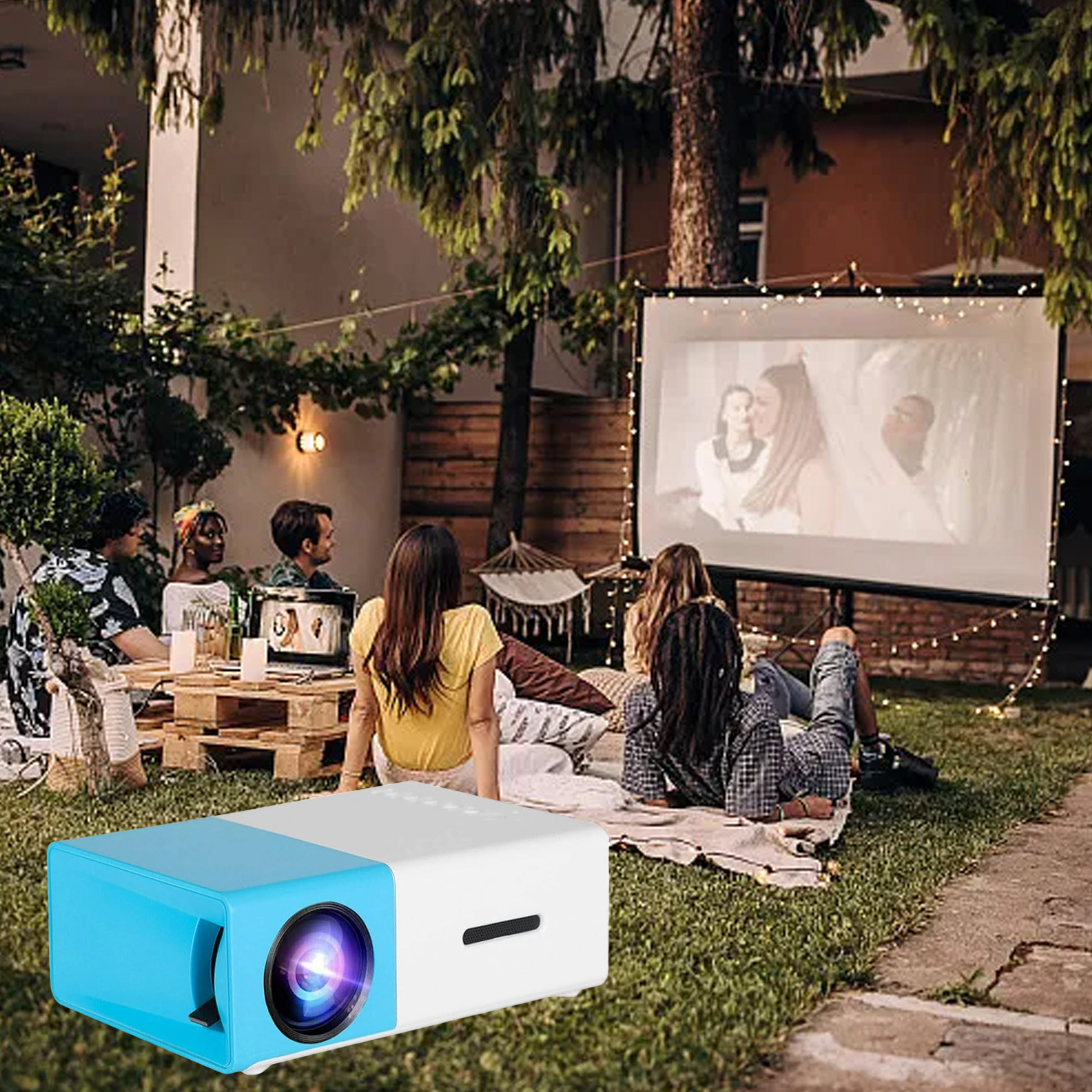 Eine Szene im Freien mit einem Projektor, der eine Filmvorführung für eine Gruppe von Personen zeigt.