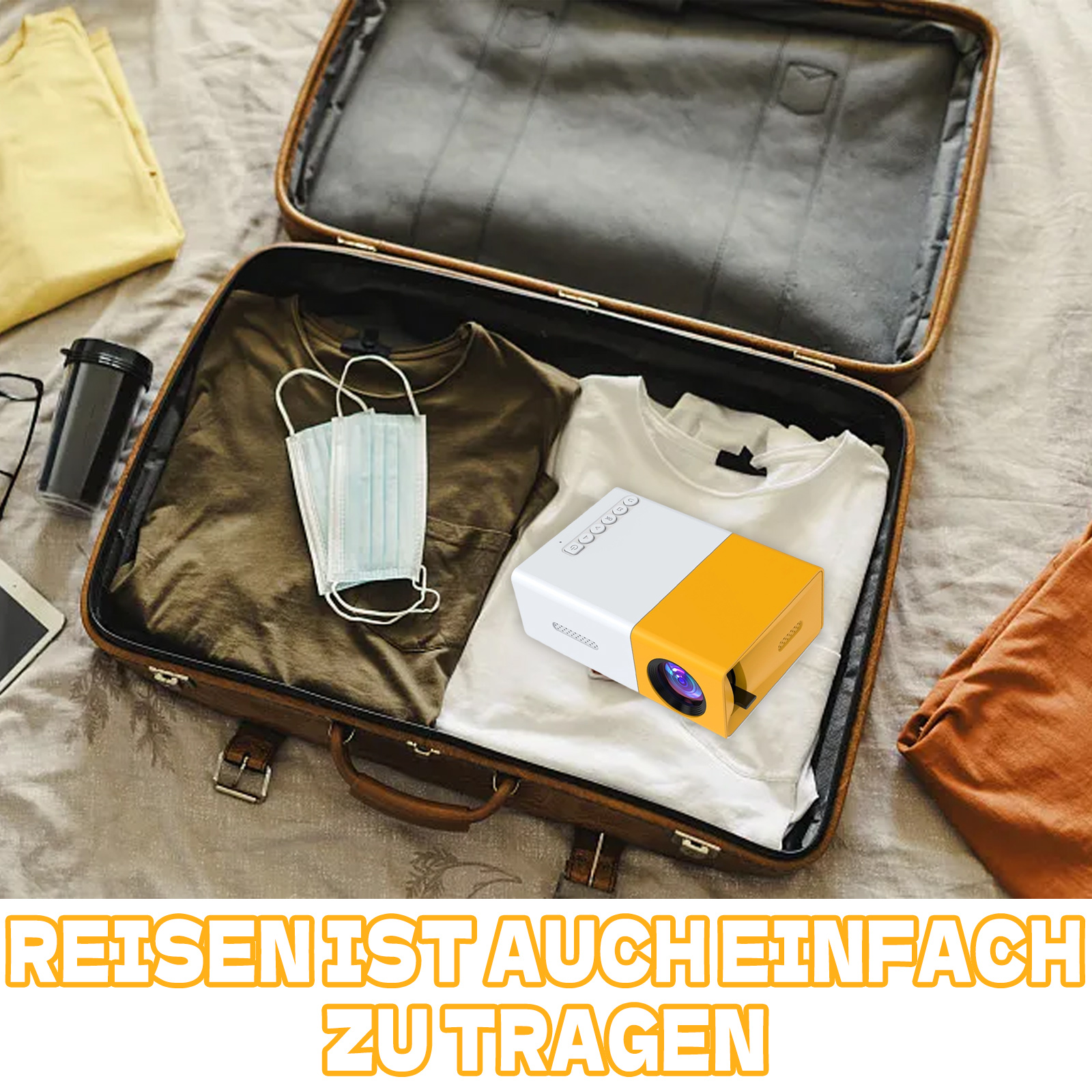 Ein Projektor in einem geöffneten Koffer mit Kleidung und einer Gesichtsmaske.