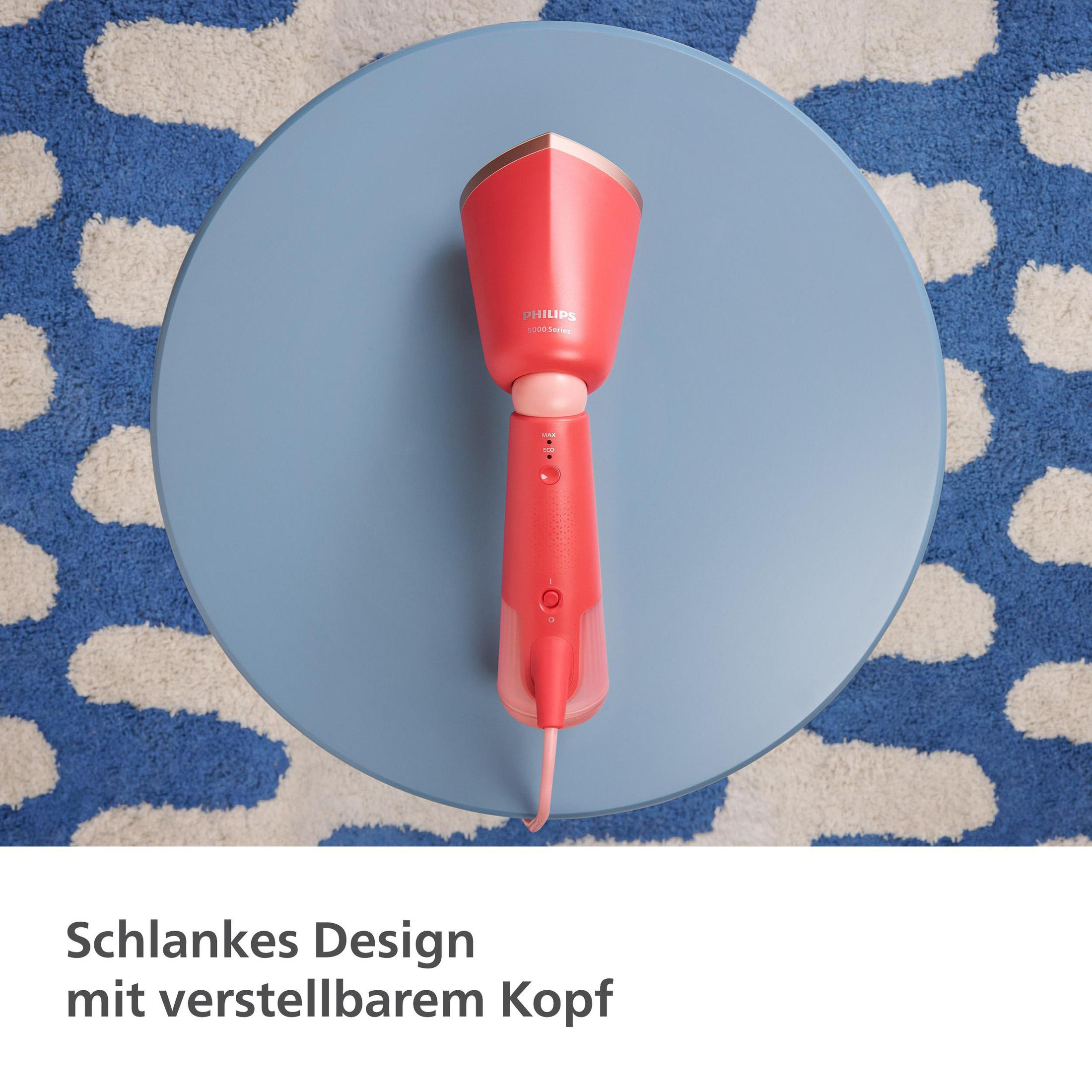 Roter Dampfer auf blauem Tisch mit gemustertem Teppich. Der Dampfer ist eine Draufsicht.