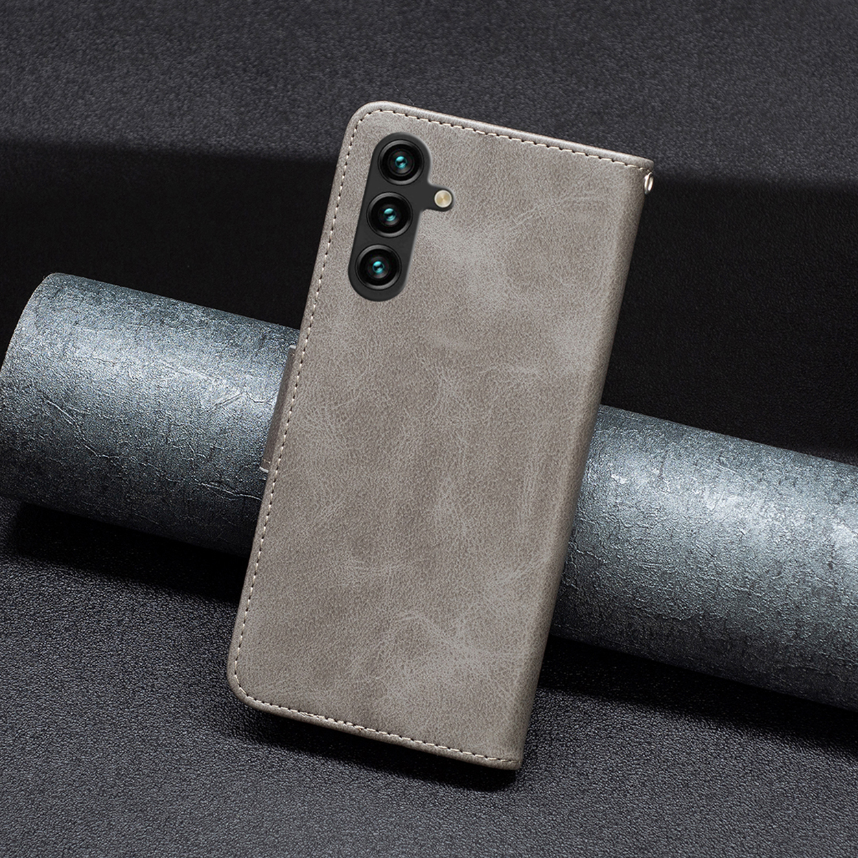 Een grijze telefoonhoes. Toont gesloten en de achterkant met de telefoon erin.