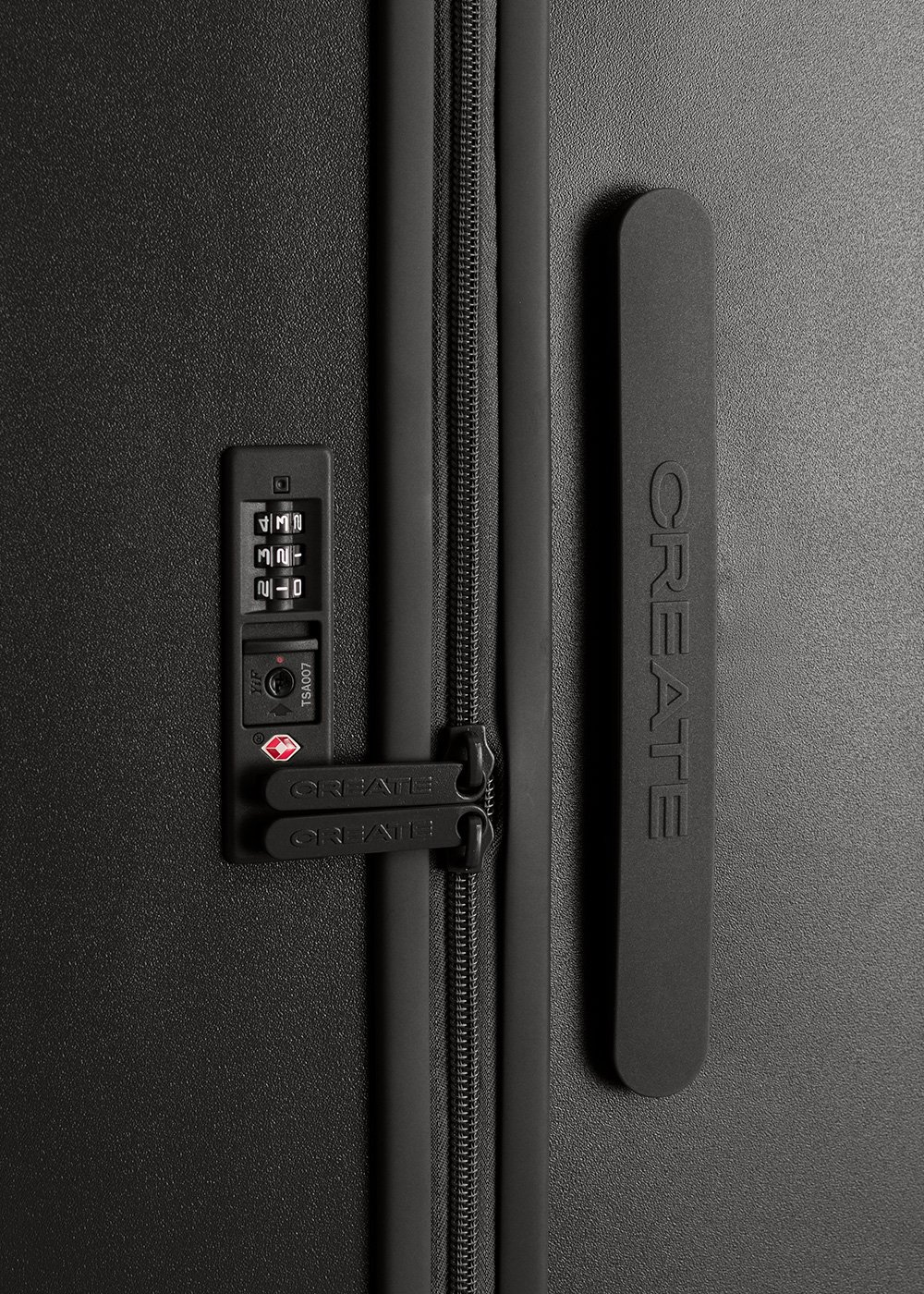 Primer plano de la cerradura de una maleta negra, que muestra el dial de combinación y la marca 'CREATE', enfatizando la seguridad y los detalles de diseño.