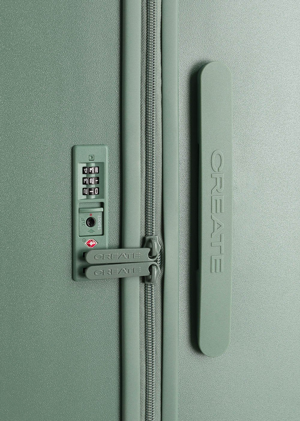 Primer plano de la cerradura de una maleta verde, que muestra el dial de combinación y la marca 'CREATE', enfatizando la seguridad y los detalles de diseño.