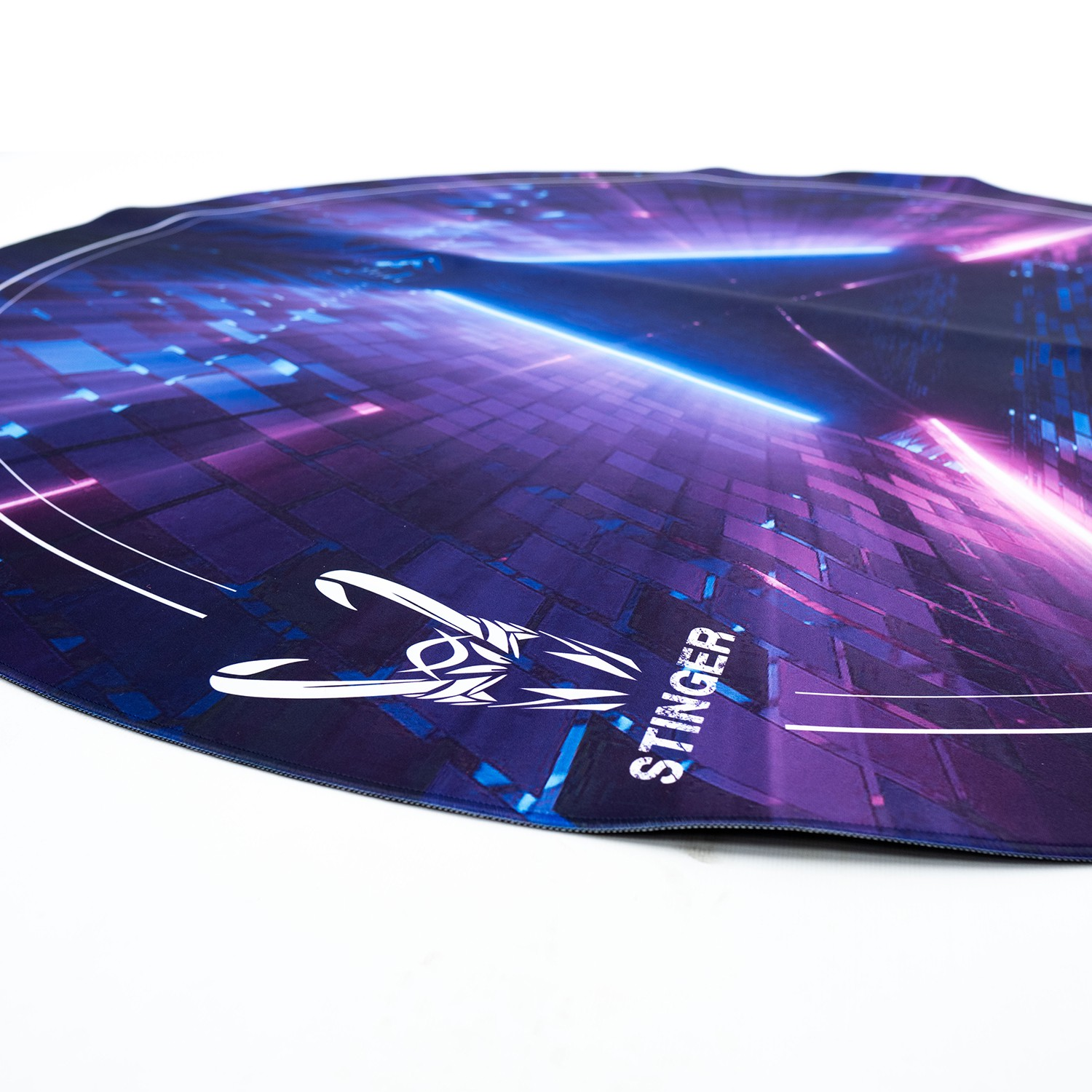 Alfombrilla gaming con gráficos morados/azules. 'STINGER' y logo visibles. Borde y fondo blancos.