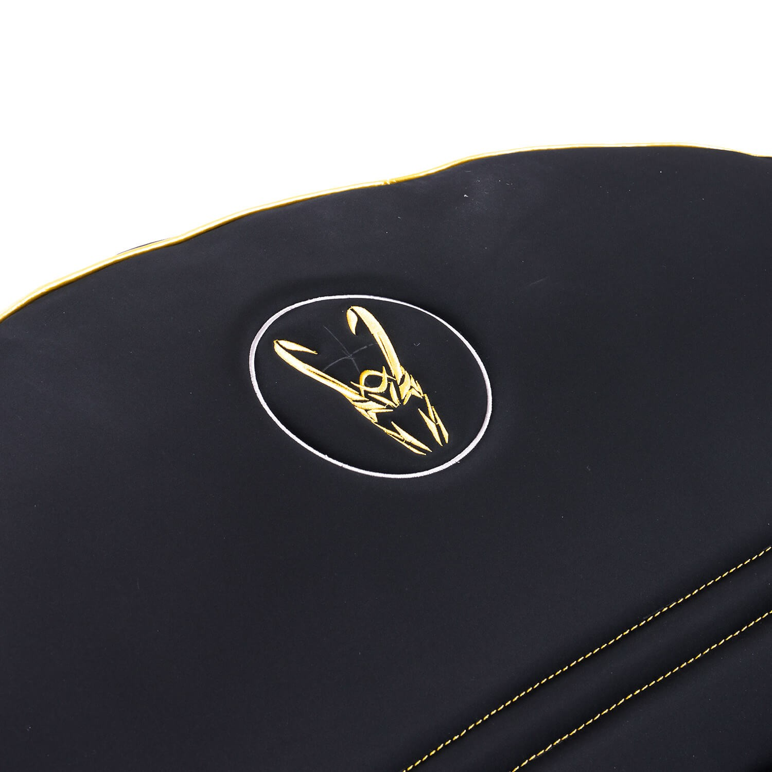 Detalle de silla gaming negra. Ribete dorado, símbolo dorado en óvalo blanco en el respaldo.