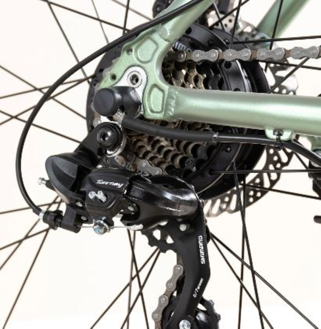 Primo piano della ruota posteriore di una bicicletta, che mostra il deragliatore, la catena e gli ingranaggi. Componenti neri e argentati su sfondo bianco.