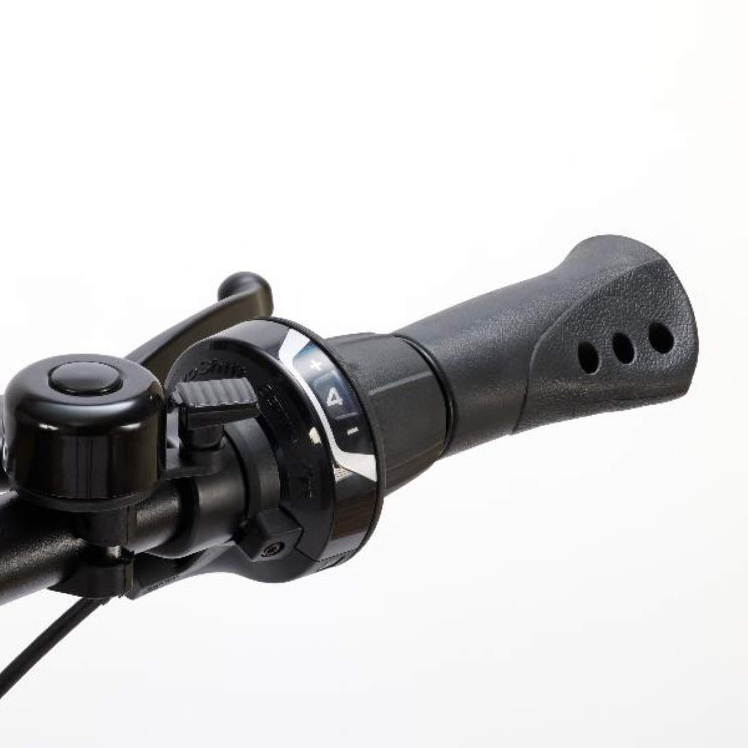 Zbliżenie kierownicy roweru z dzwonkiem i kontrolą biegów. Rower jest czarny.