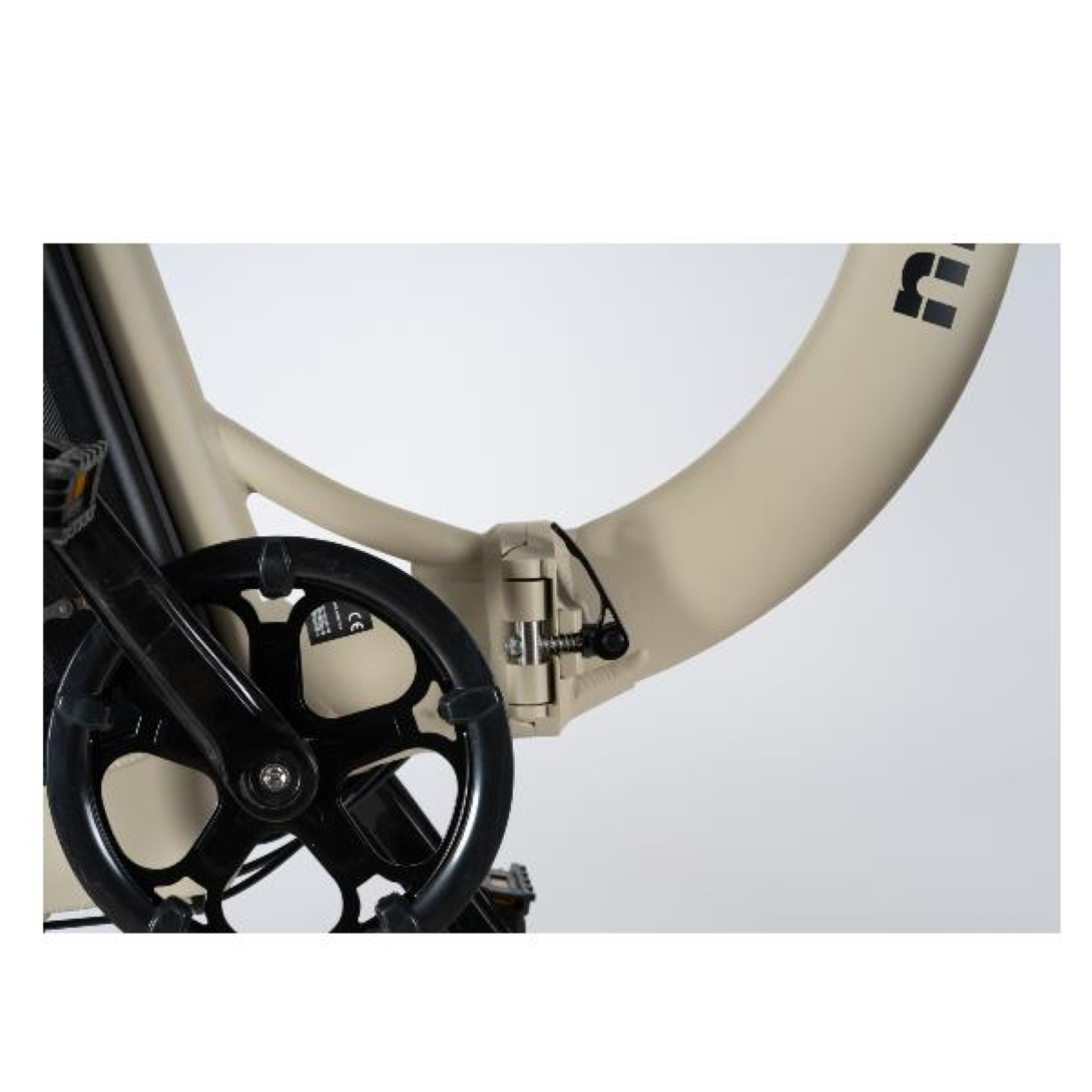 Primer plano del cuadro de la bicicleta, la biela y los pedales. El cuadro es beige. La biela y el pedal son negros.