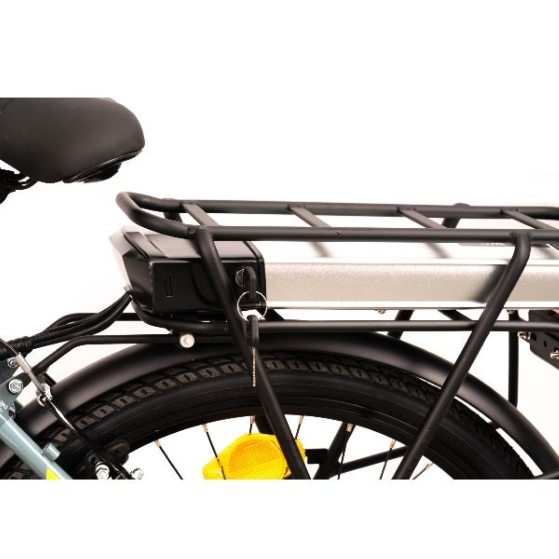 Primo piano di una bici elettrica, portapacchi nero, batteria, pneumatico posteriore e catarifrangente giallo. Lo sfondo è bianco.