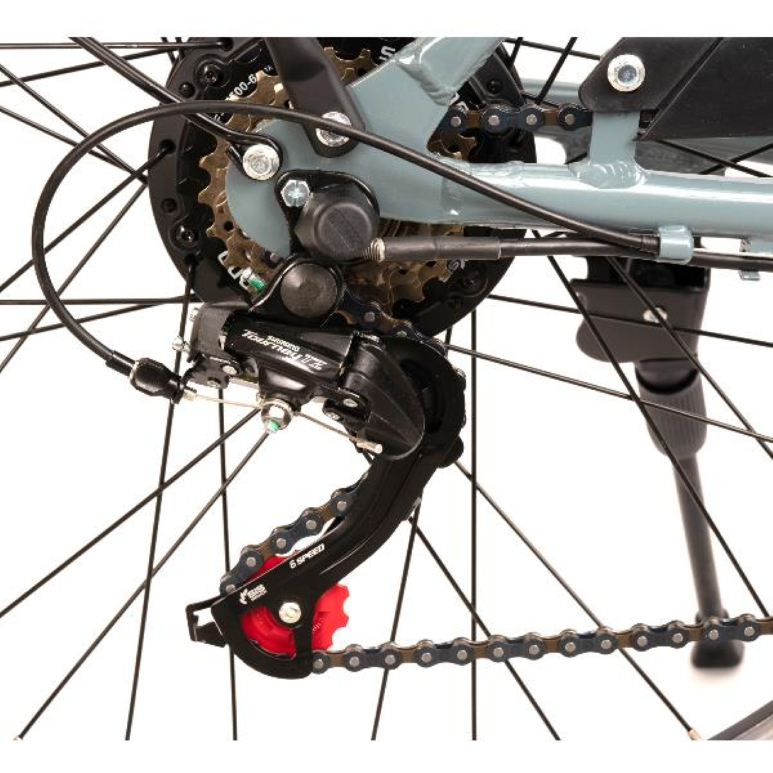 Primo piano dei componenti della ruota posteriore di una e-bike. L'immagine include il deragliatore, gli ingranaggi, la catena e un cavalletto.