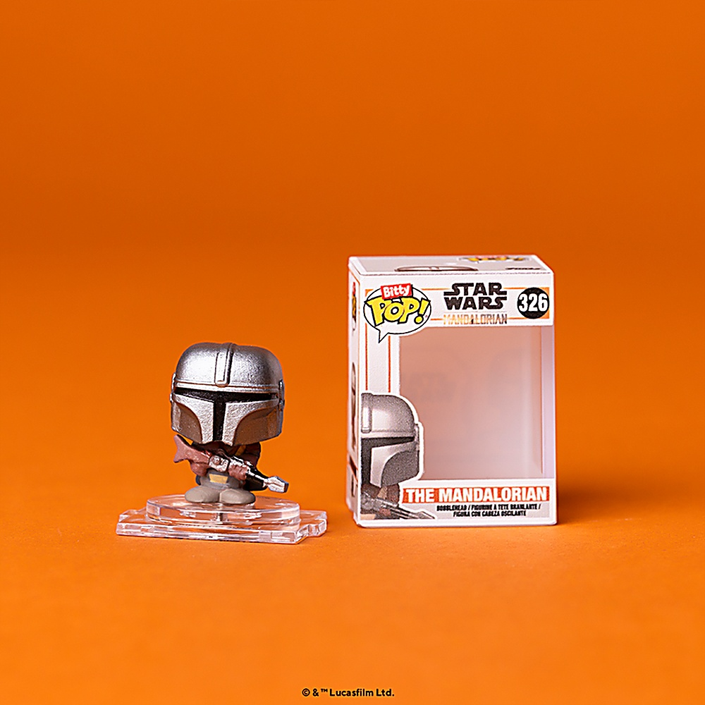 Figurka Funko Pop Mandaloriana i jej pudełko. Pomarańczowe tło.
