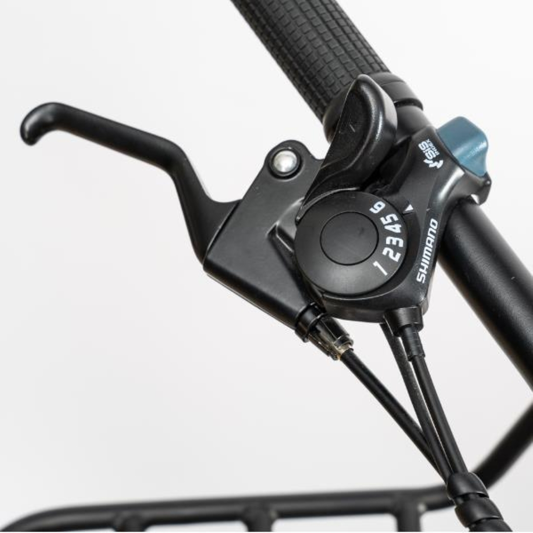 Cambio marce per bicicletta nero con numeri 1-6. Marchio Shimano. Sono visibili anche la leva e il cavo neri.