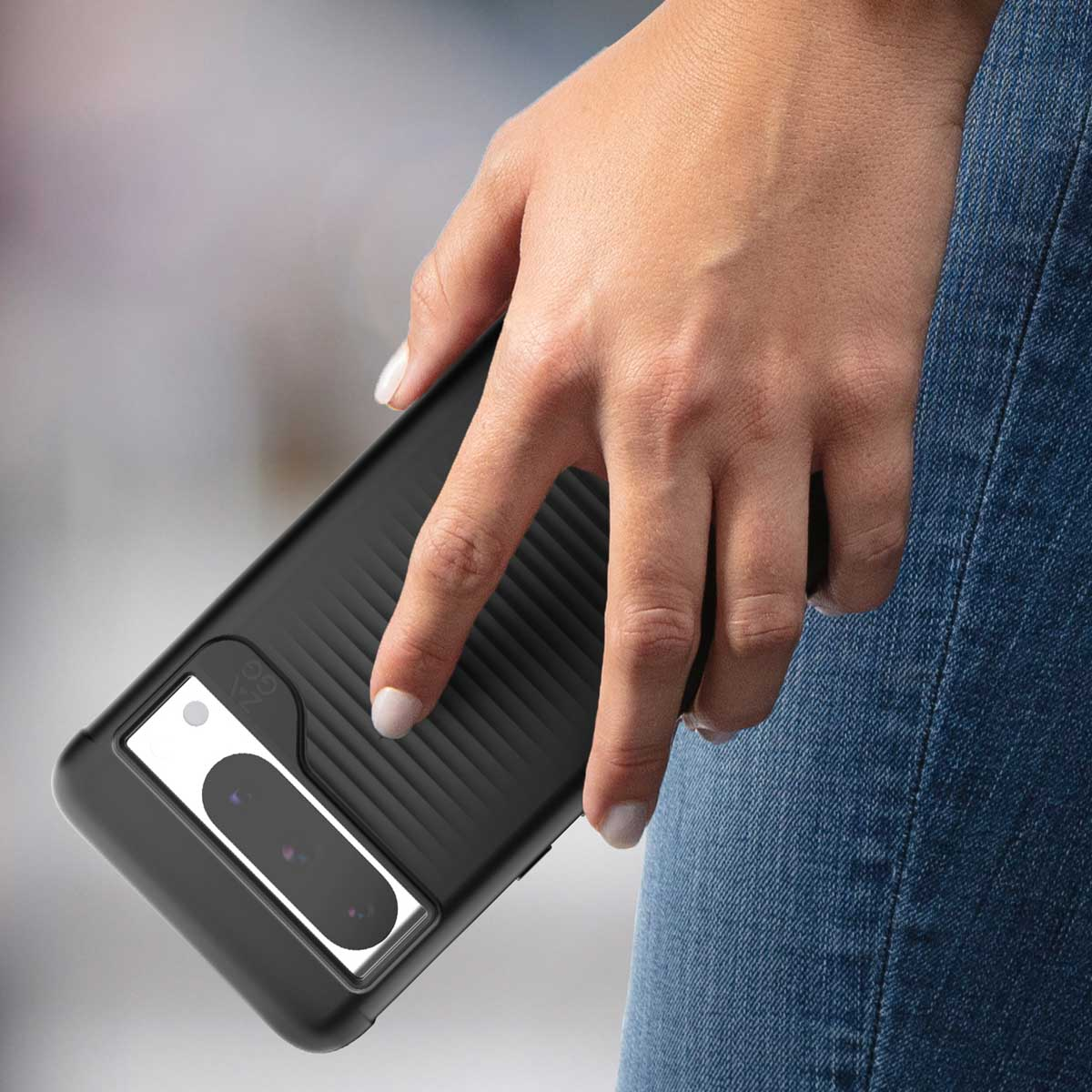 Een hand die een zwarte telefoonhoes vasthoudt met een kaartsleuf. De hoes heeft een witte rechthoek. Jeans op de achtergrond.