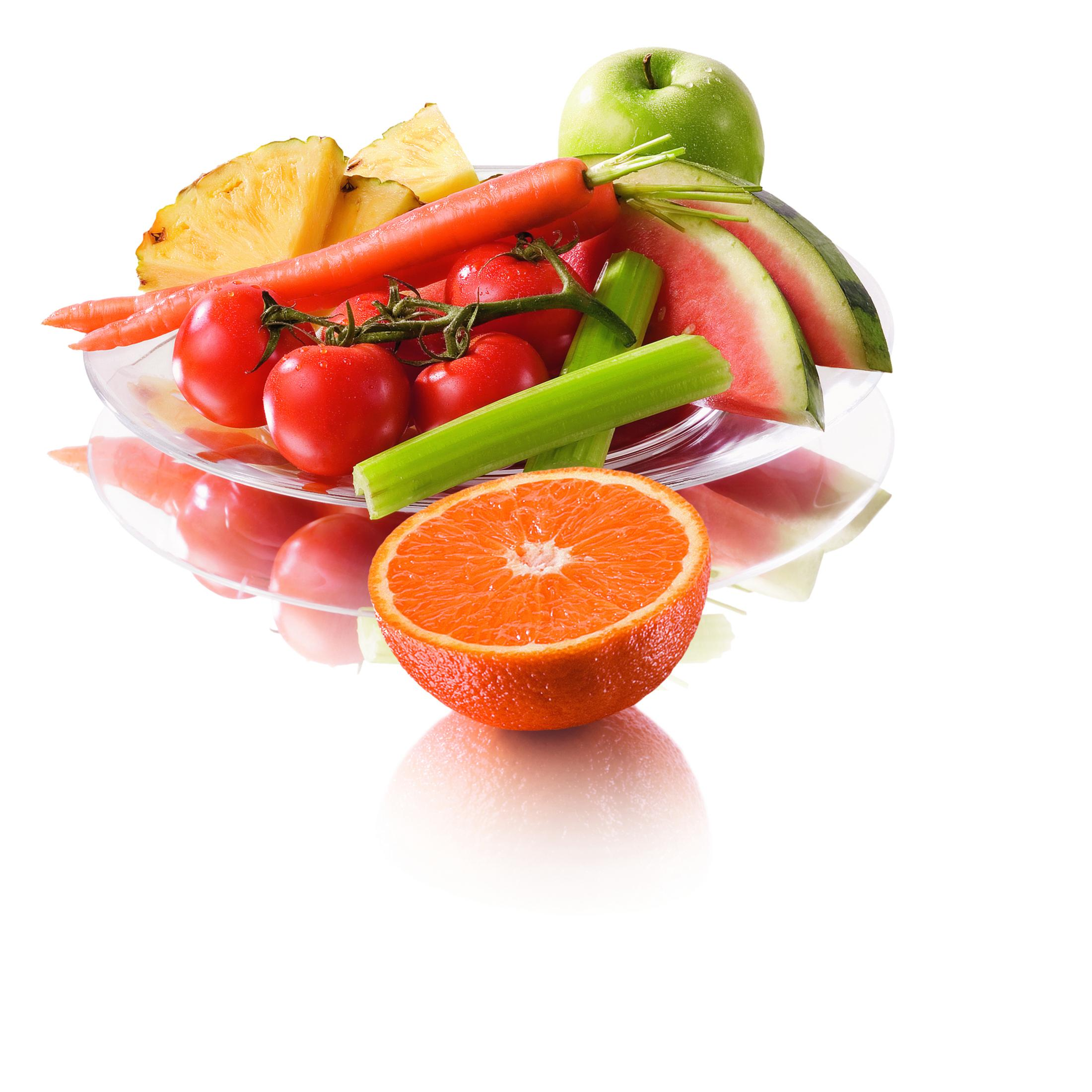 Ein Teller mit geschnittenen Früchten und Gemüse, darunter Tomaten, Karotten, Wassermelone. Eine halbe Orange liegt davor.