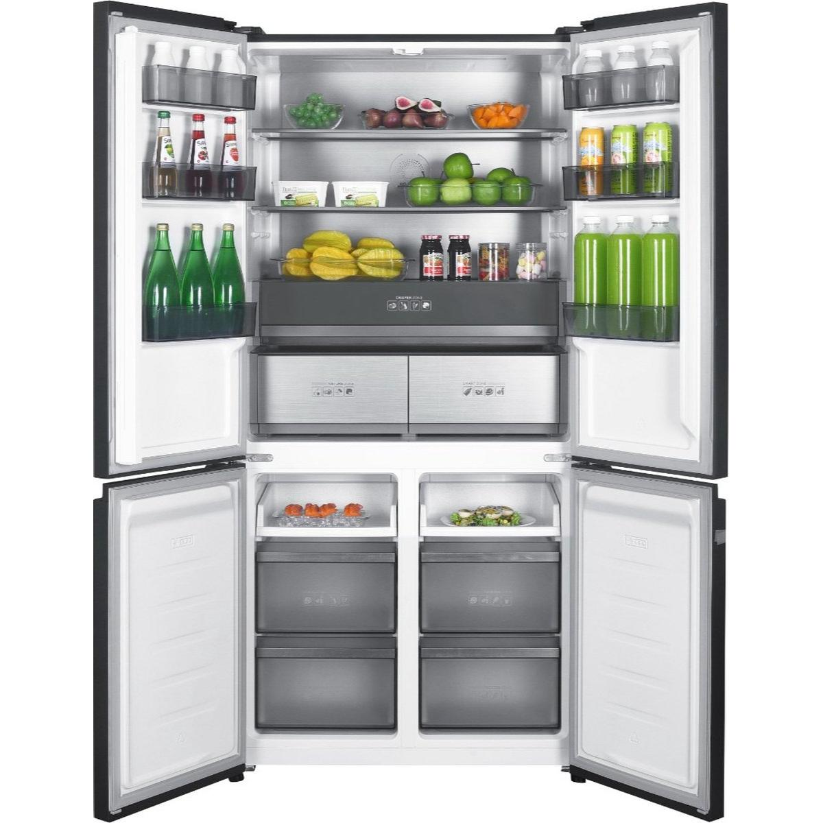 Otwarta lodówka wypełniona jedzeniem: owoce, warzywa, napoje i produkty pakowane. Drzwi są otwarte, pokazując różne przegrody.