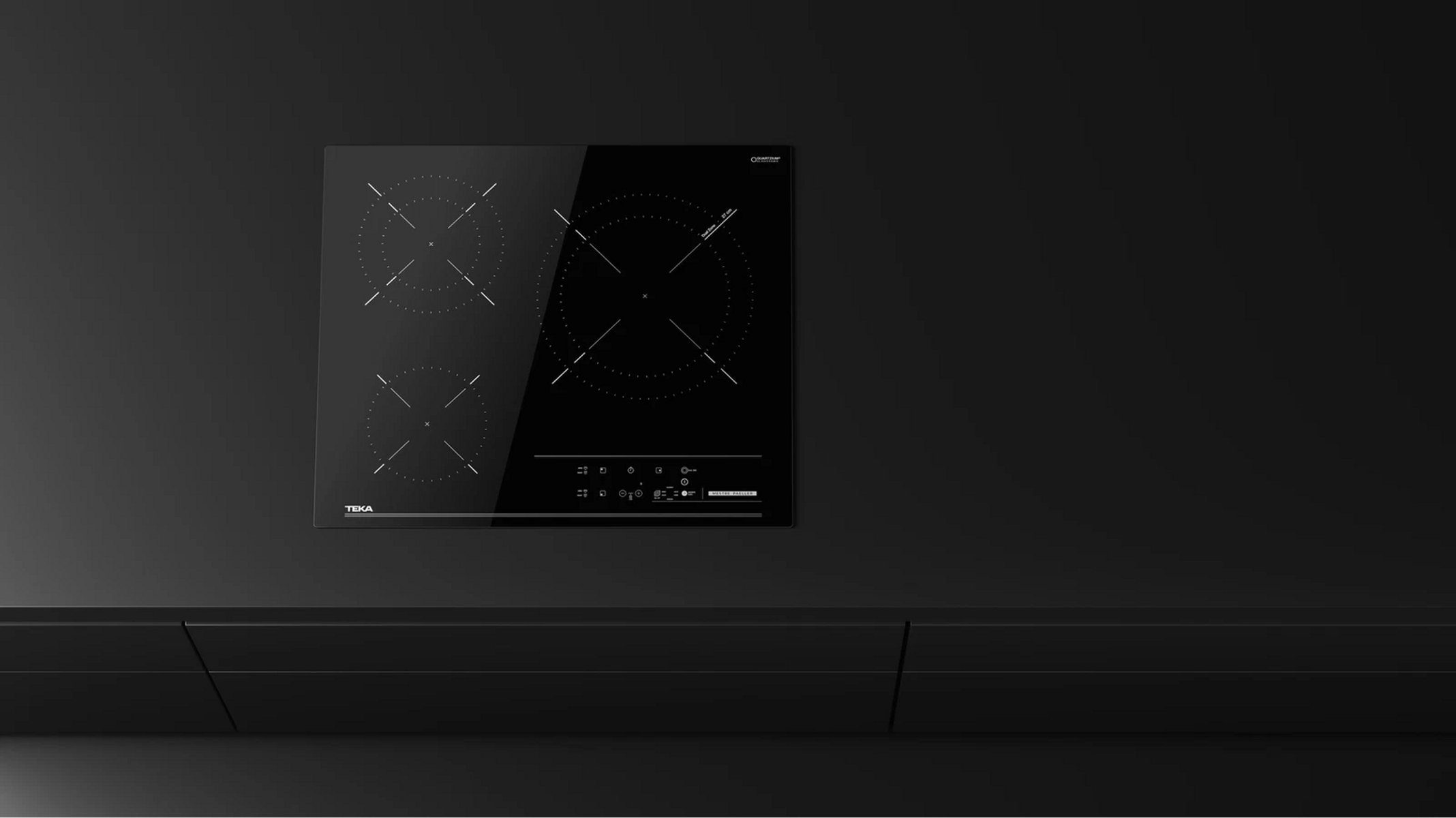 Un piano cottura a induzione nero integrato su un piano di lavoro nero, design minimal.
