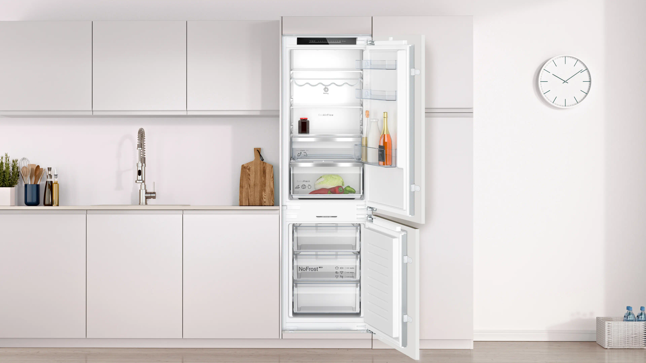 Interior de una cocina moderna con gabinetes blancos, refrigerador abierto y reloj en la pared.