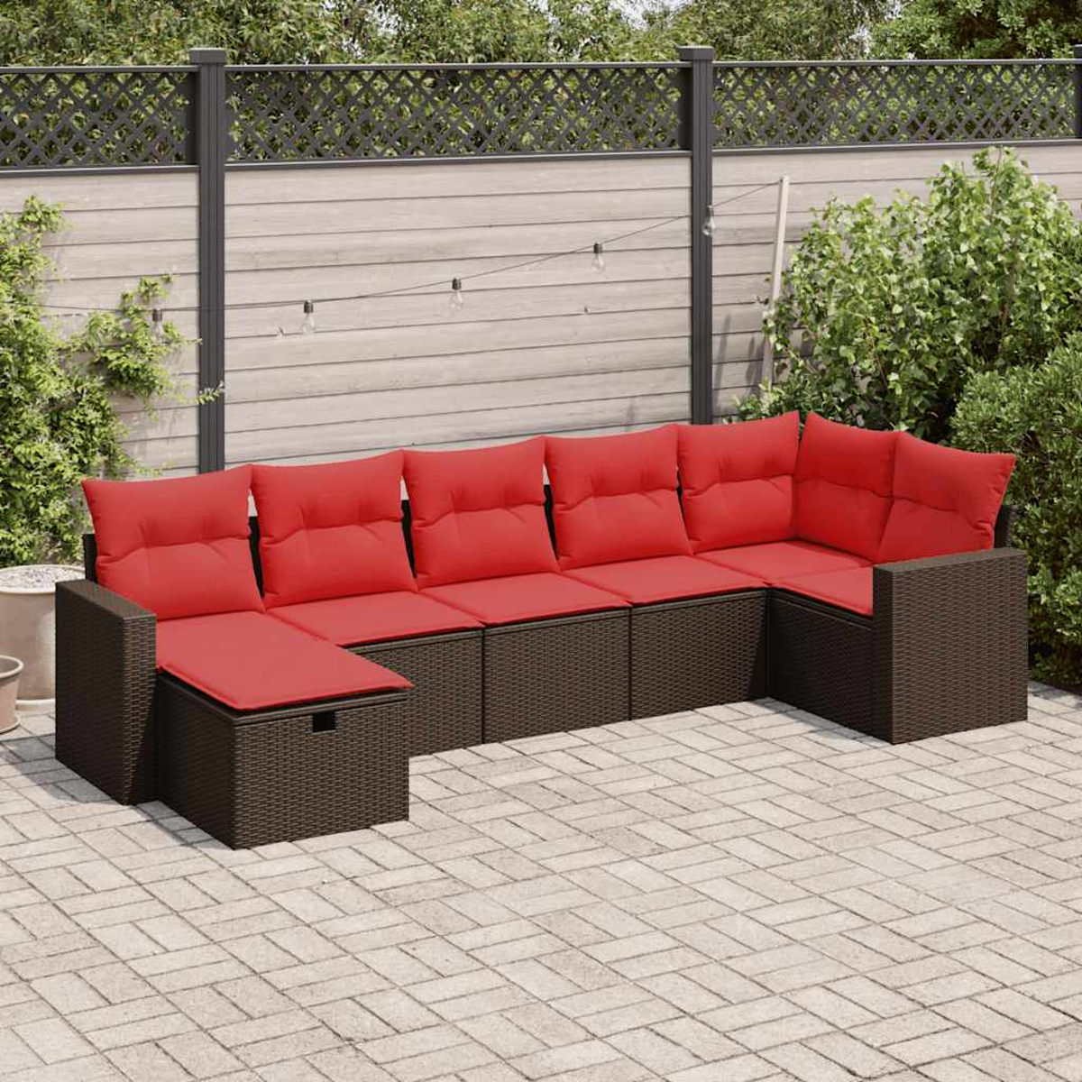 U-förmiges Outdoor-Ecksofa mit roten Kissen auf einer Ziegelterrasse.