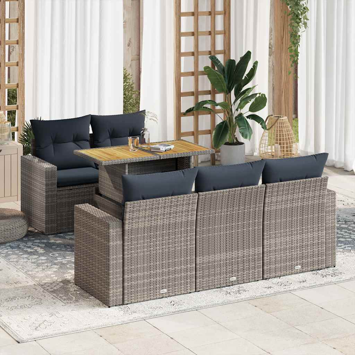 Un juego de muebles de mimbre para exteriores que incluye un sofá, una mesa y plantas en un patio.